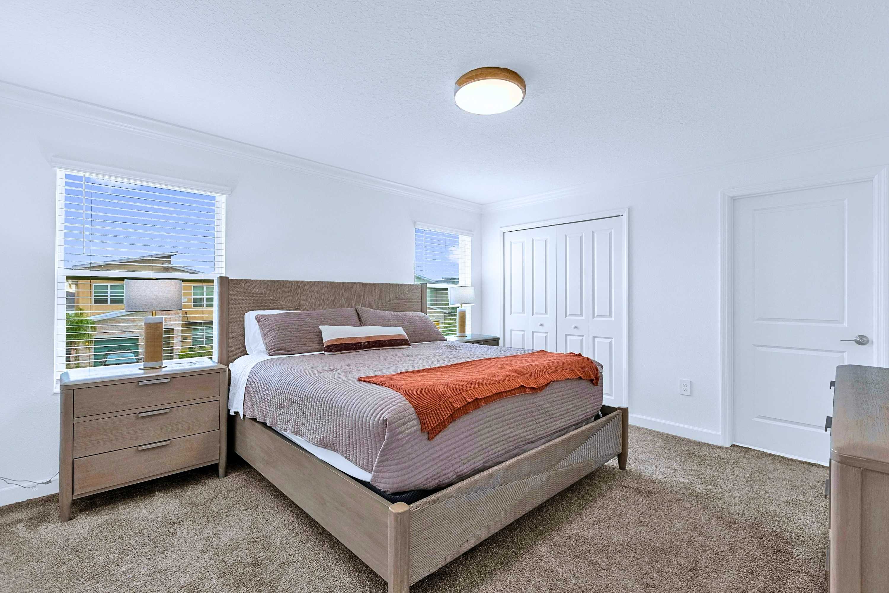 Comfortable Queen bed styled with premium bedding, plush pillows, and dual side lamps.