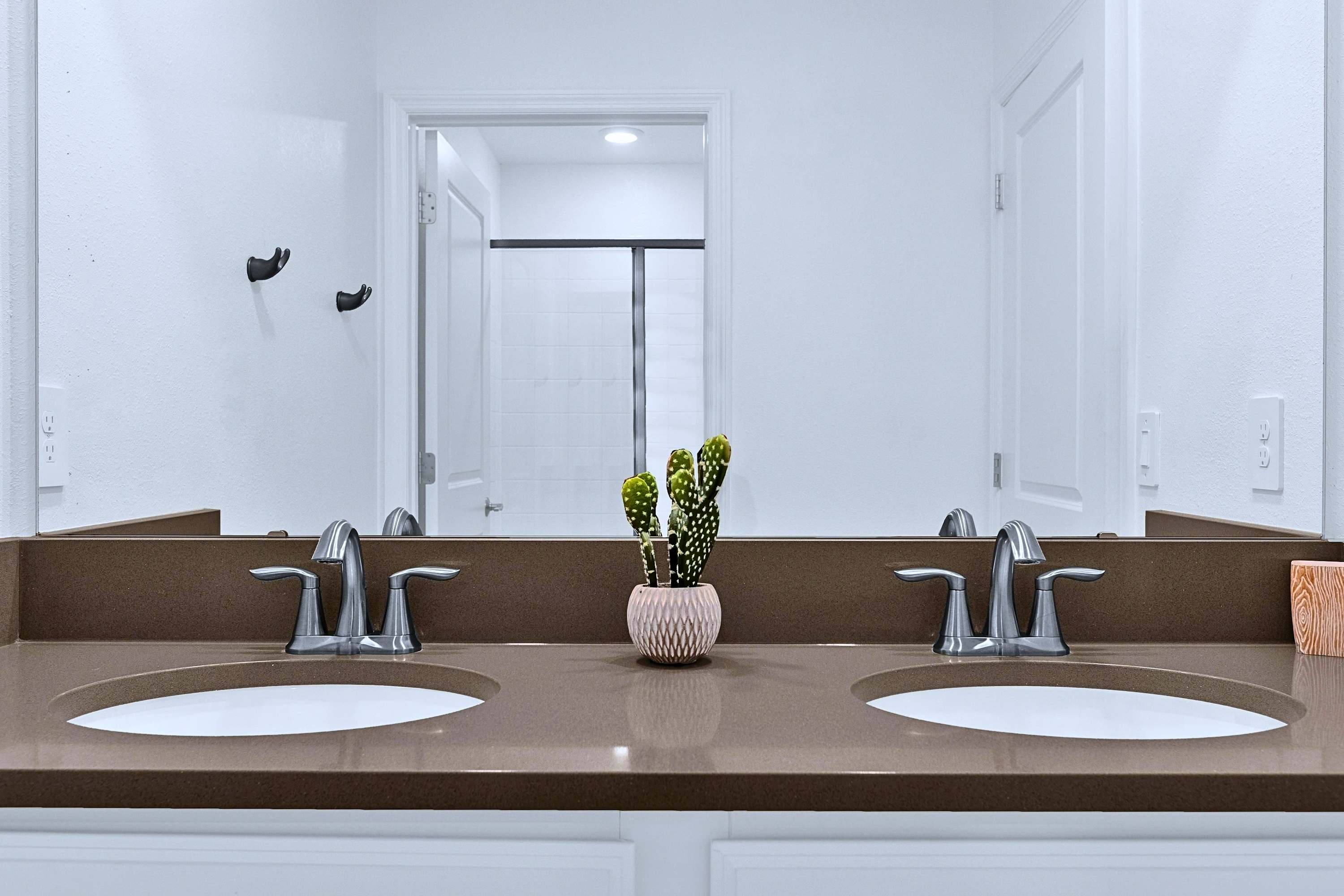 Double-sink vanity bathroom complete with a full wall mirror and fresh amenities.
