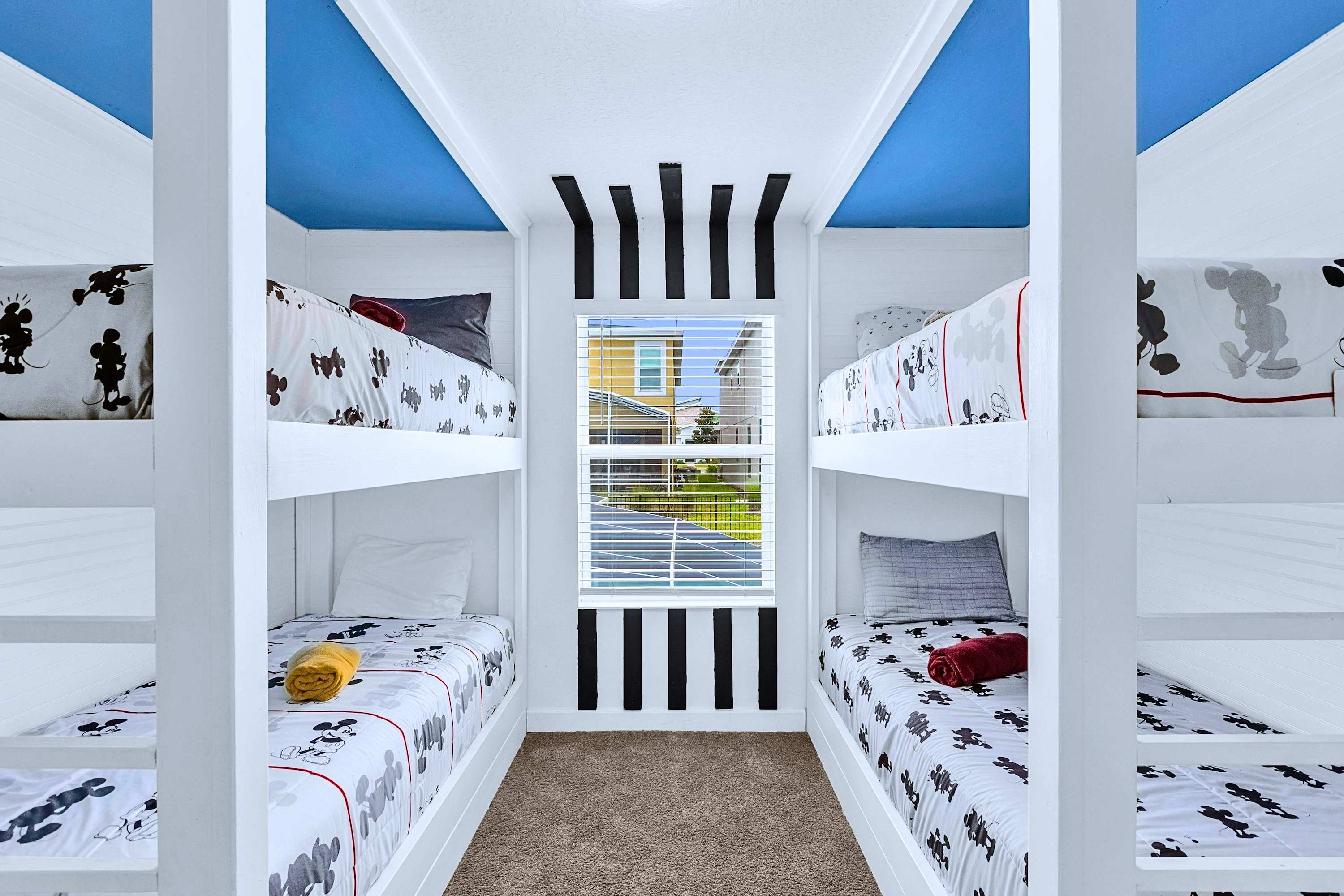 Mickey Mouse-themed bedroom featuring two single bunk beds for young guests.