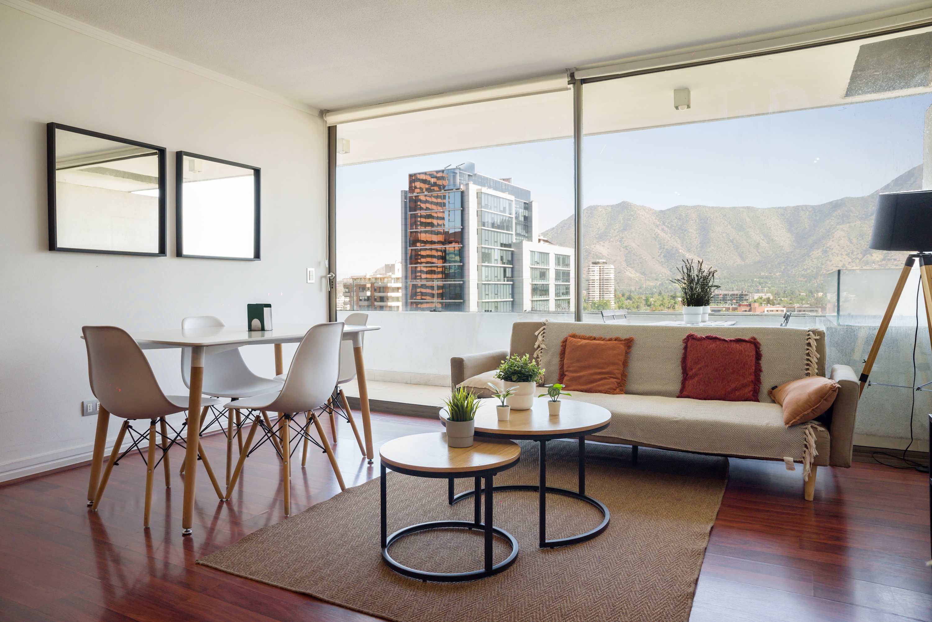 Bright living and dining room with floor-to-ceiling windows framing sweeping mountain views, plus a comfortable sofa and table for relaxed gatherings.