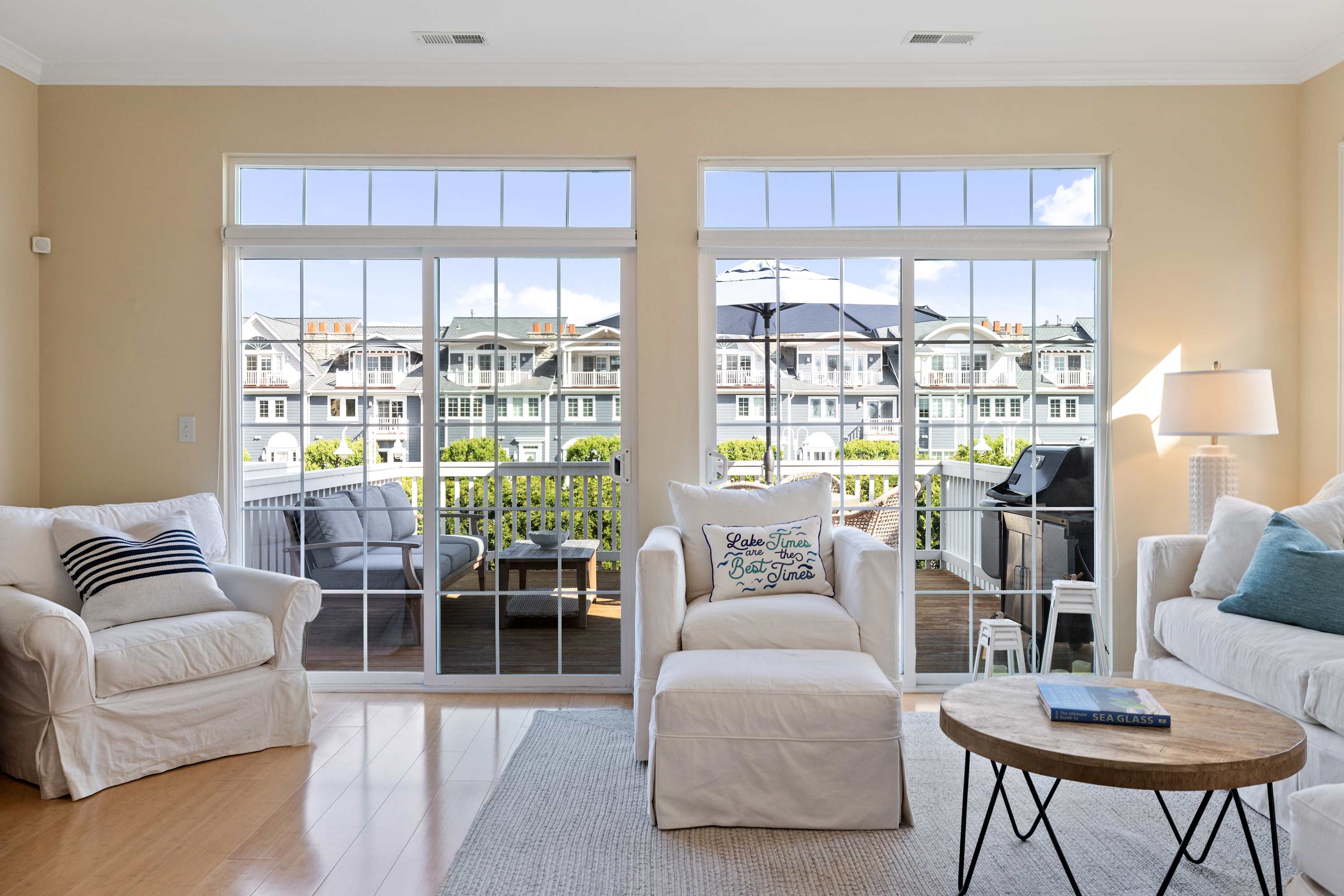 Tall glass doors fill the living room with daylight and balcony views.