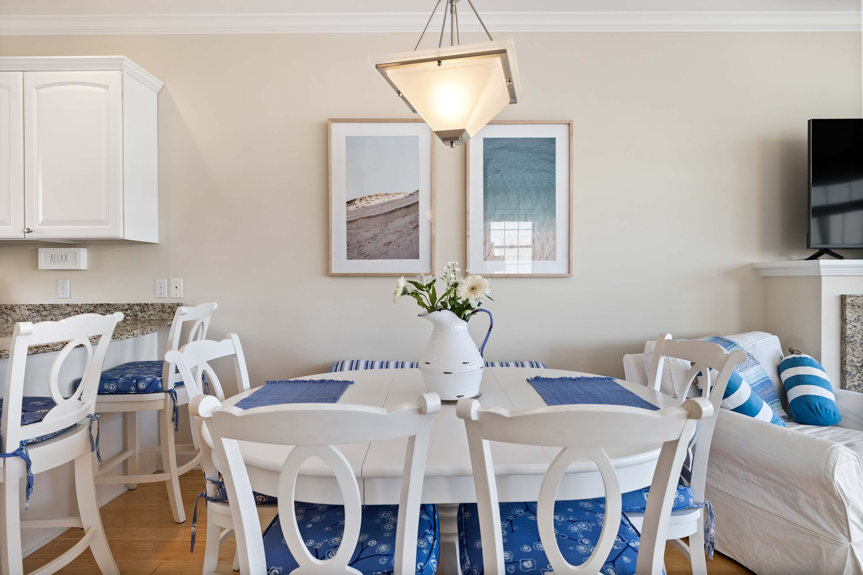 Coastal dining area with cushioned seats steps from the kitchen.