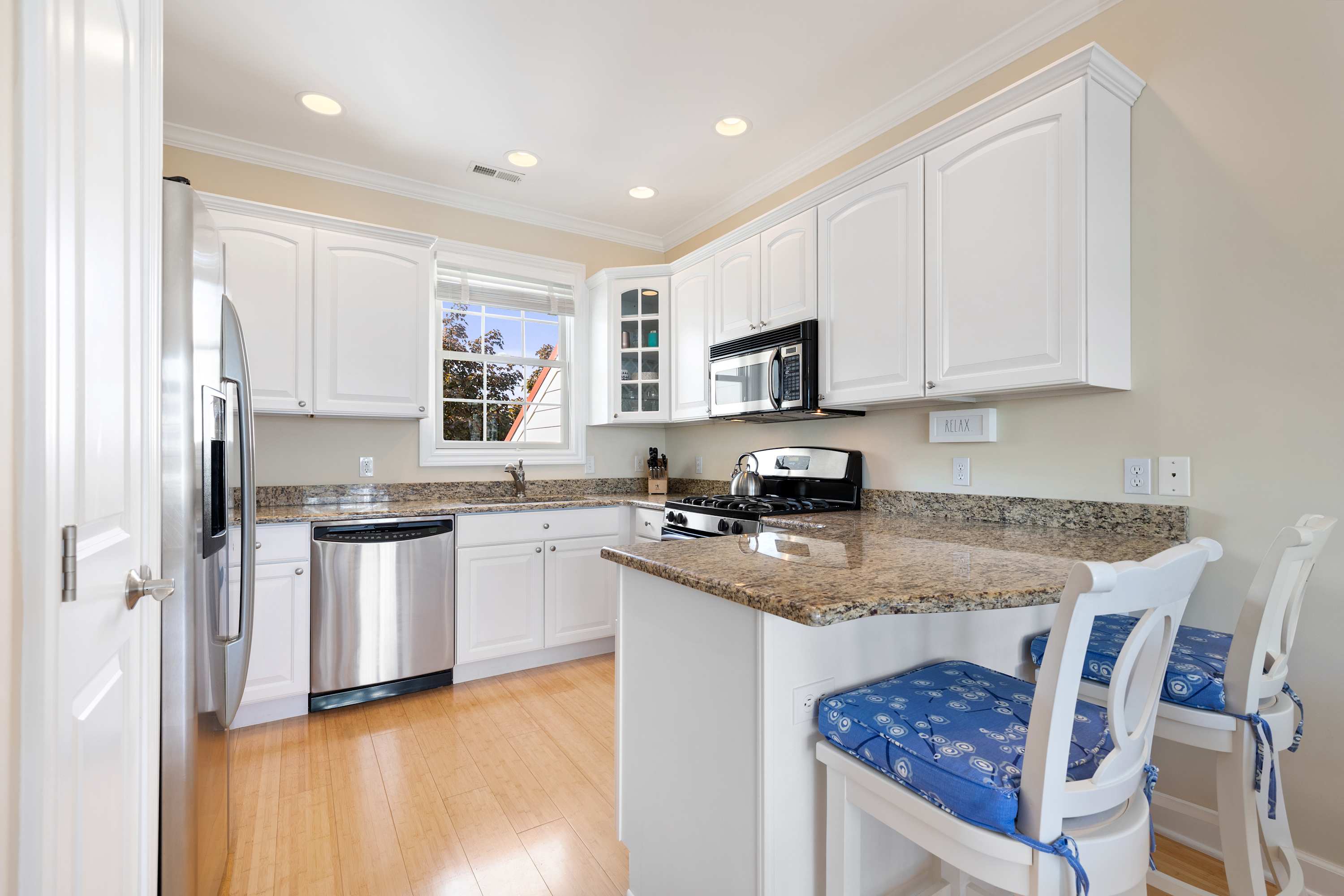 Breakfast bar seating keeps the cook company in this granite kitchen.