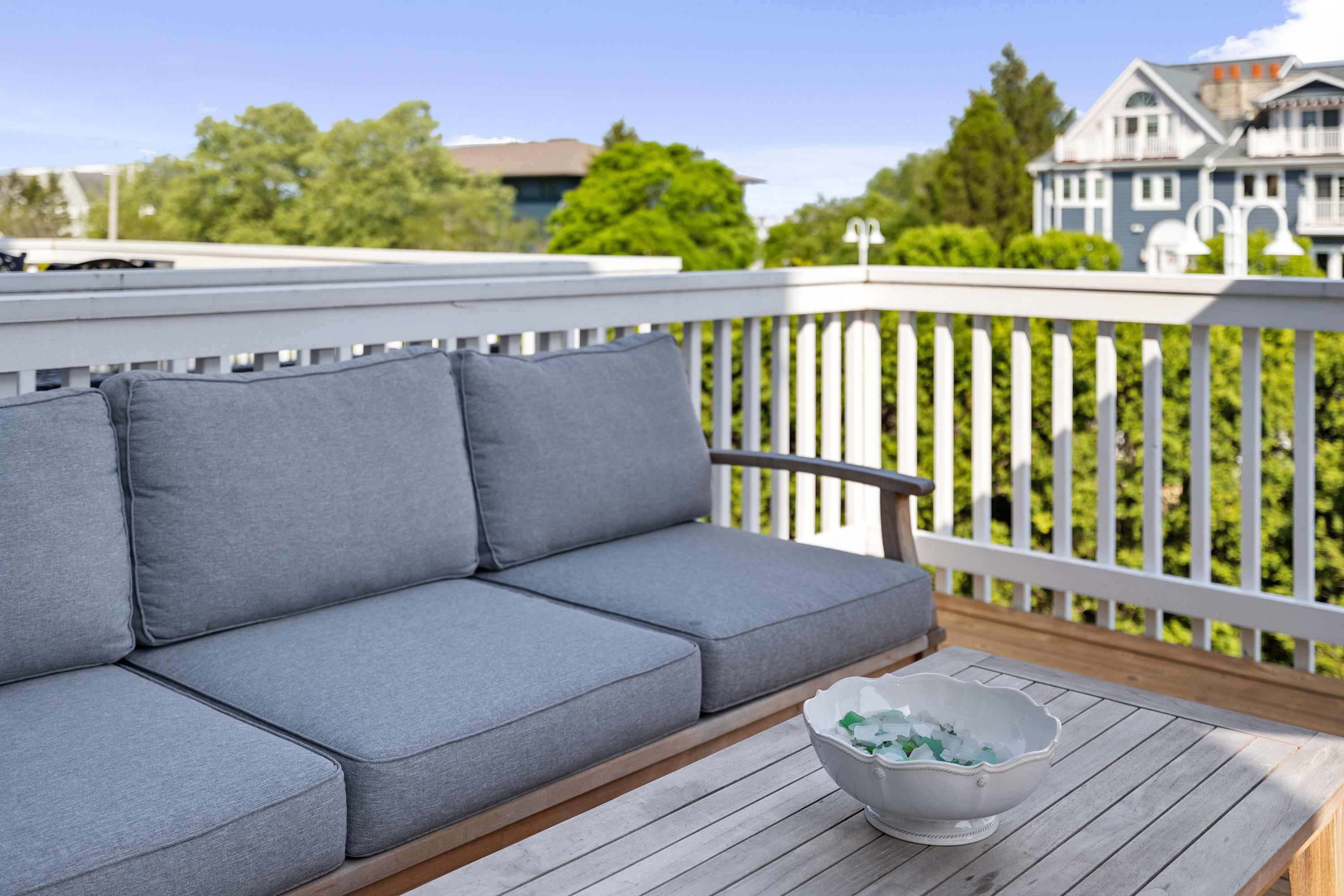 Cushioned outdoor sofa on the deck for lounging in the open air.