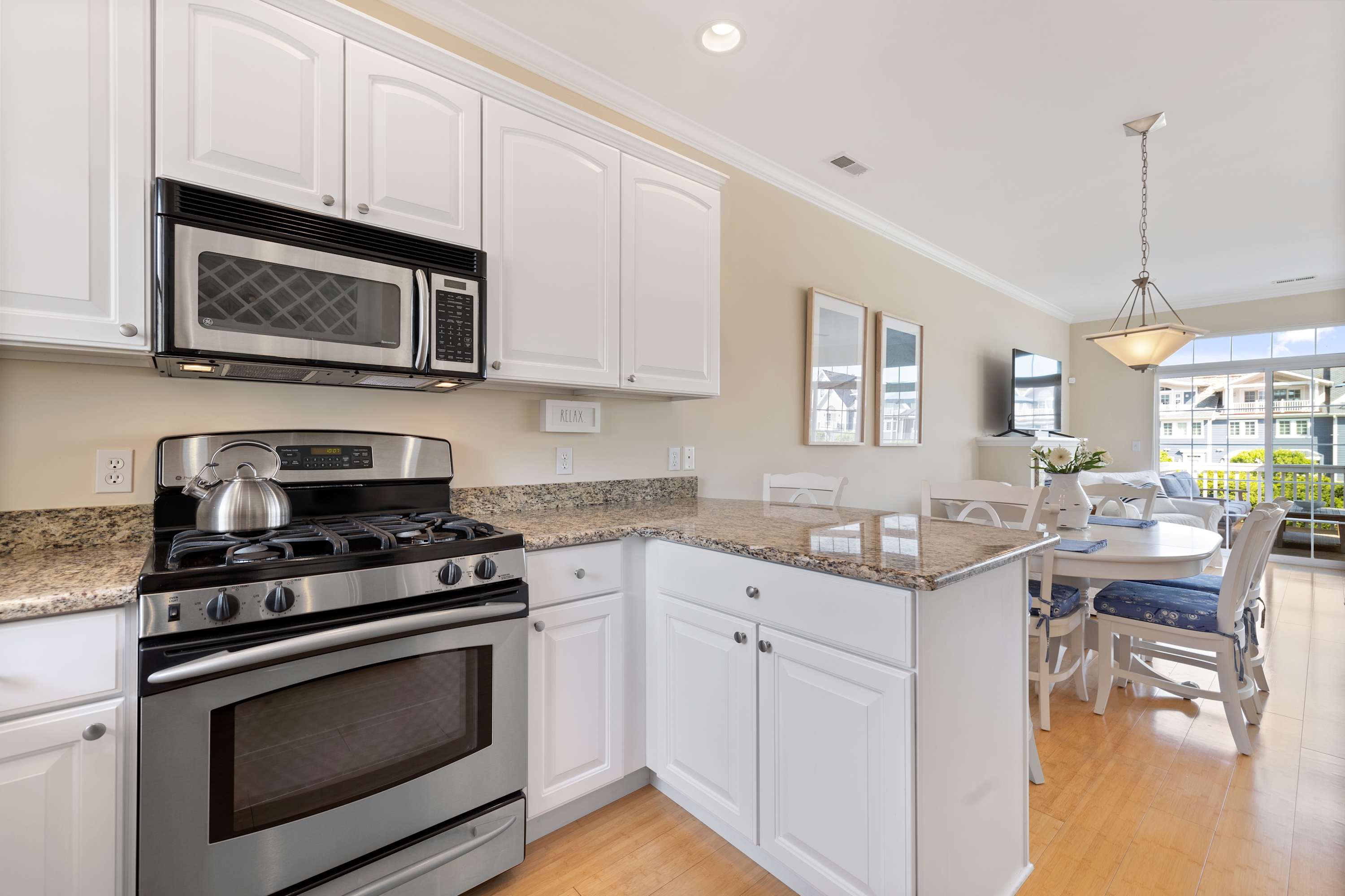 Sea Glass kitchen flowing into a bright dining area for easy serving.