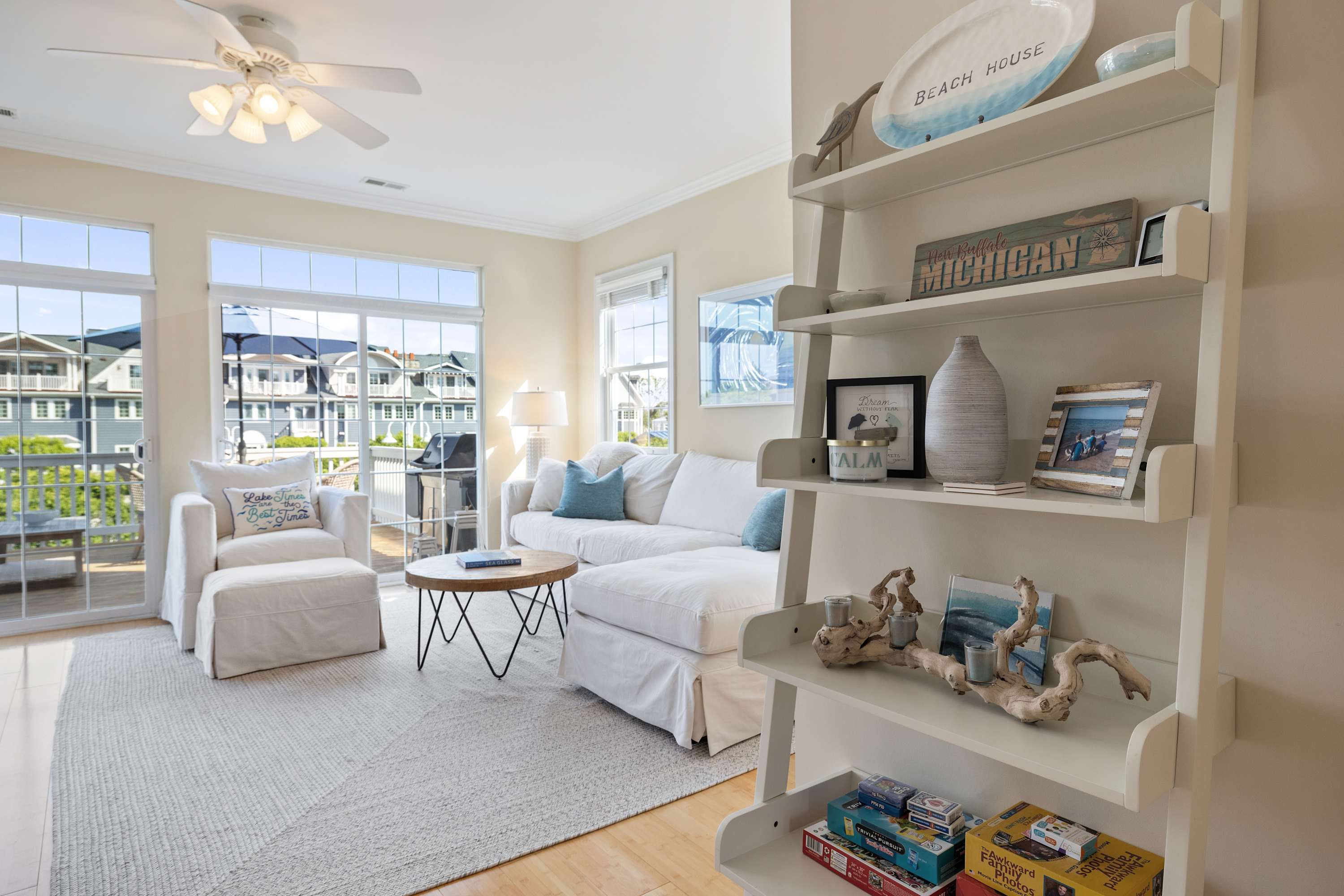 Shelves stocked with books and coastal decor beside the sofa.