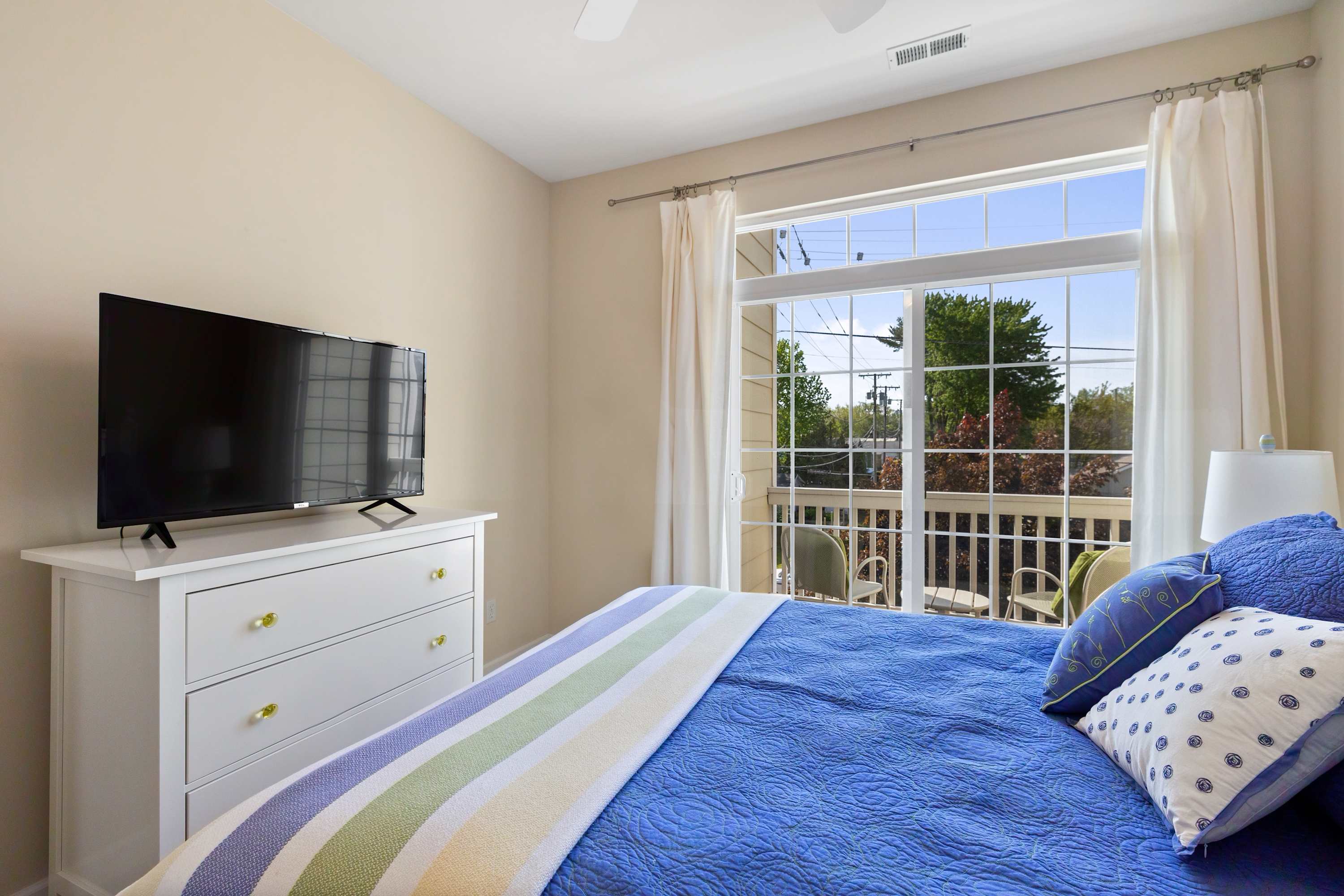 Bedroom with balcony doors and full curtains for privacy at night.