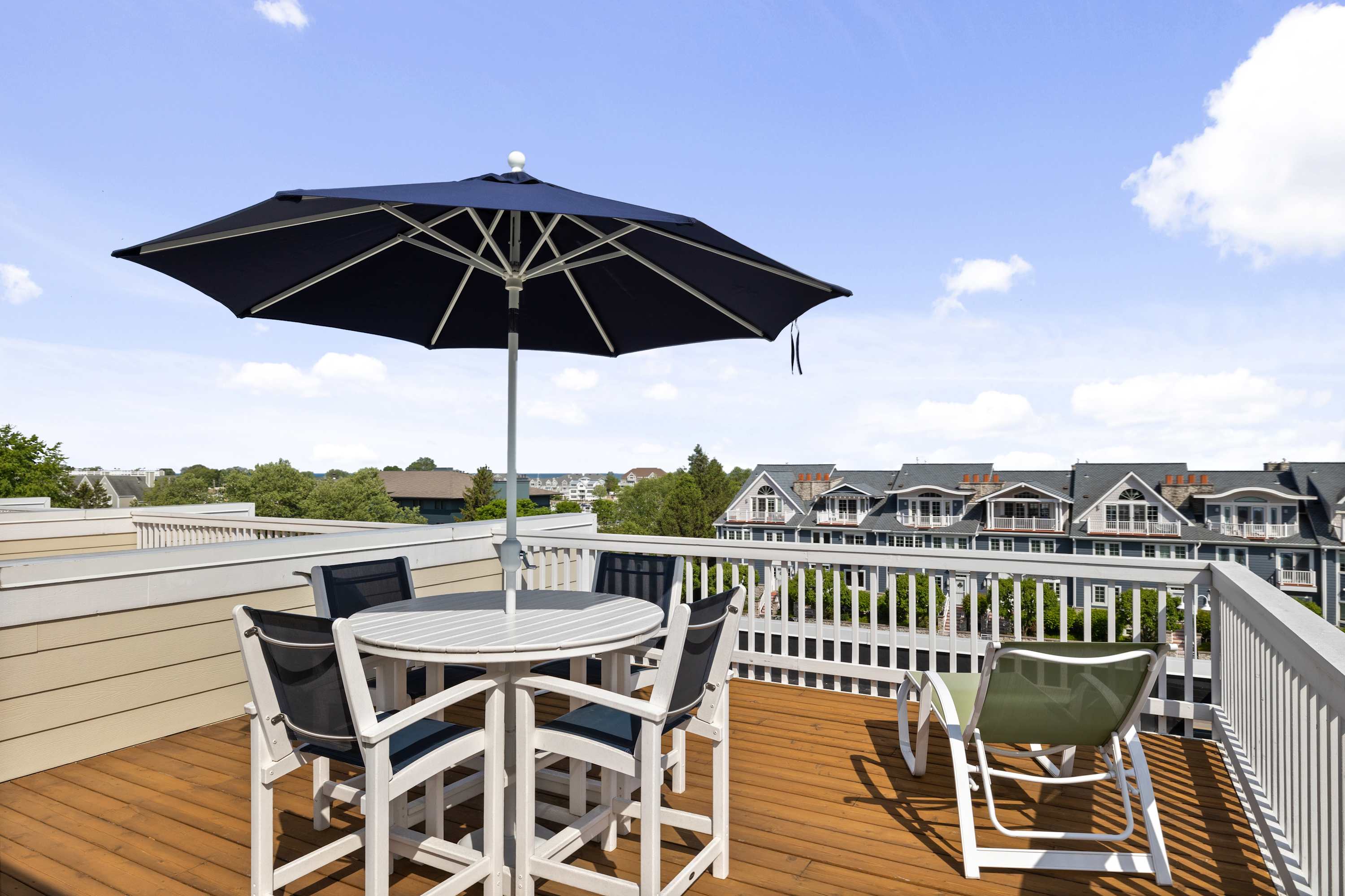 Rooftop deck with umbrella dining and open views over New Buffalo.