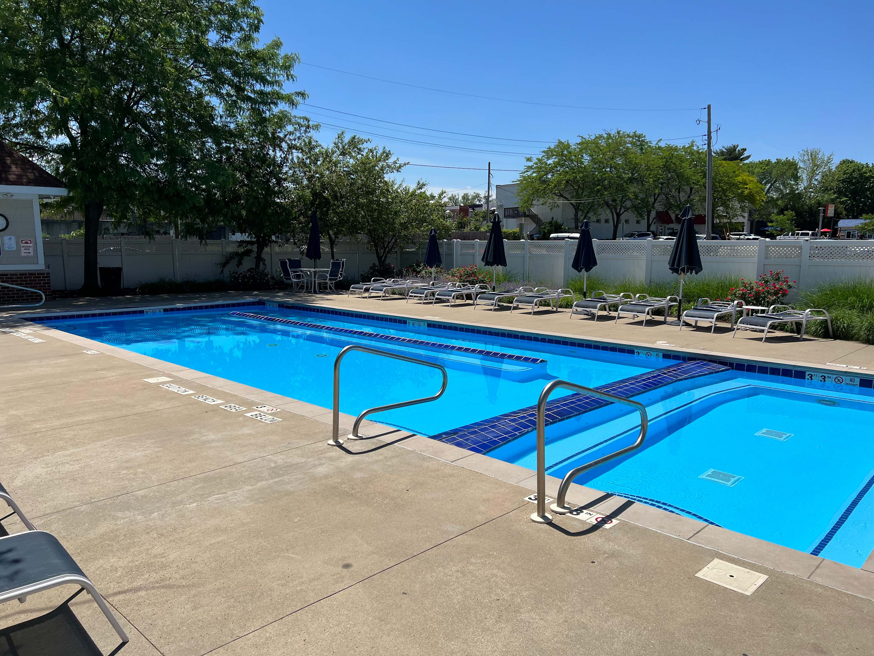 The seasonal community pool deck is lined with lounge chairs and umbrellas for shade.