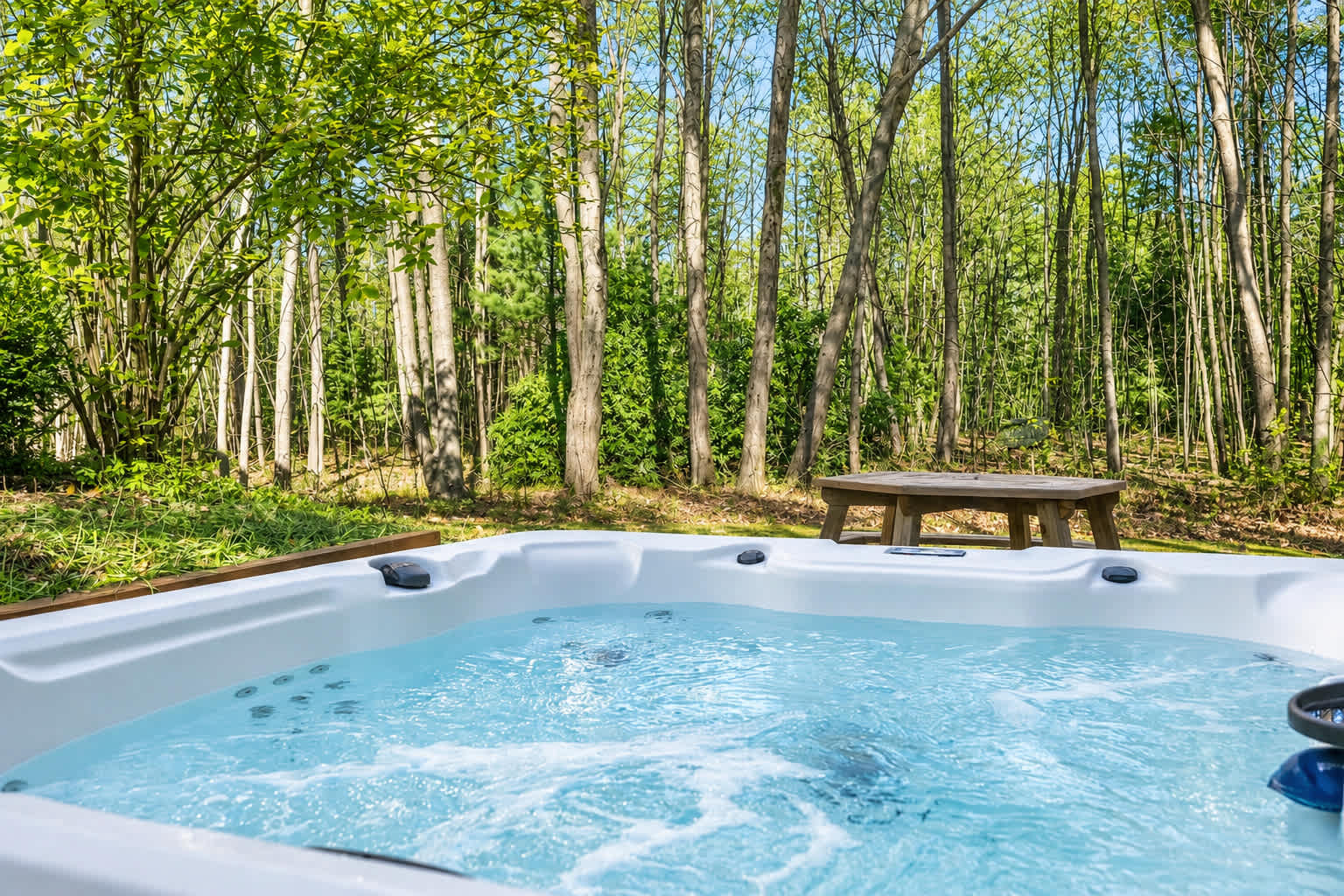 Soak in the private hot tub surrounded by peaceful wooded views