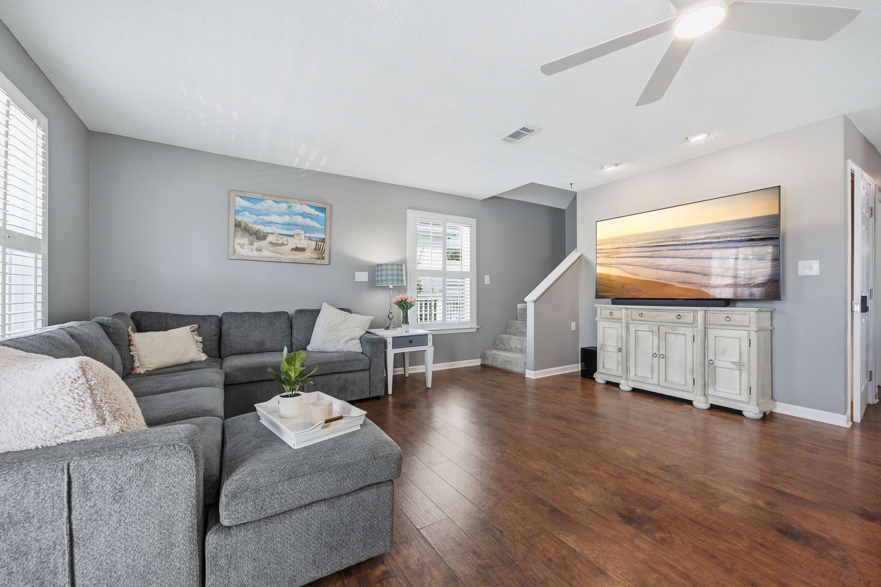 Relax in the bright, open living space with a comfortable sectional and Smart TV