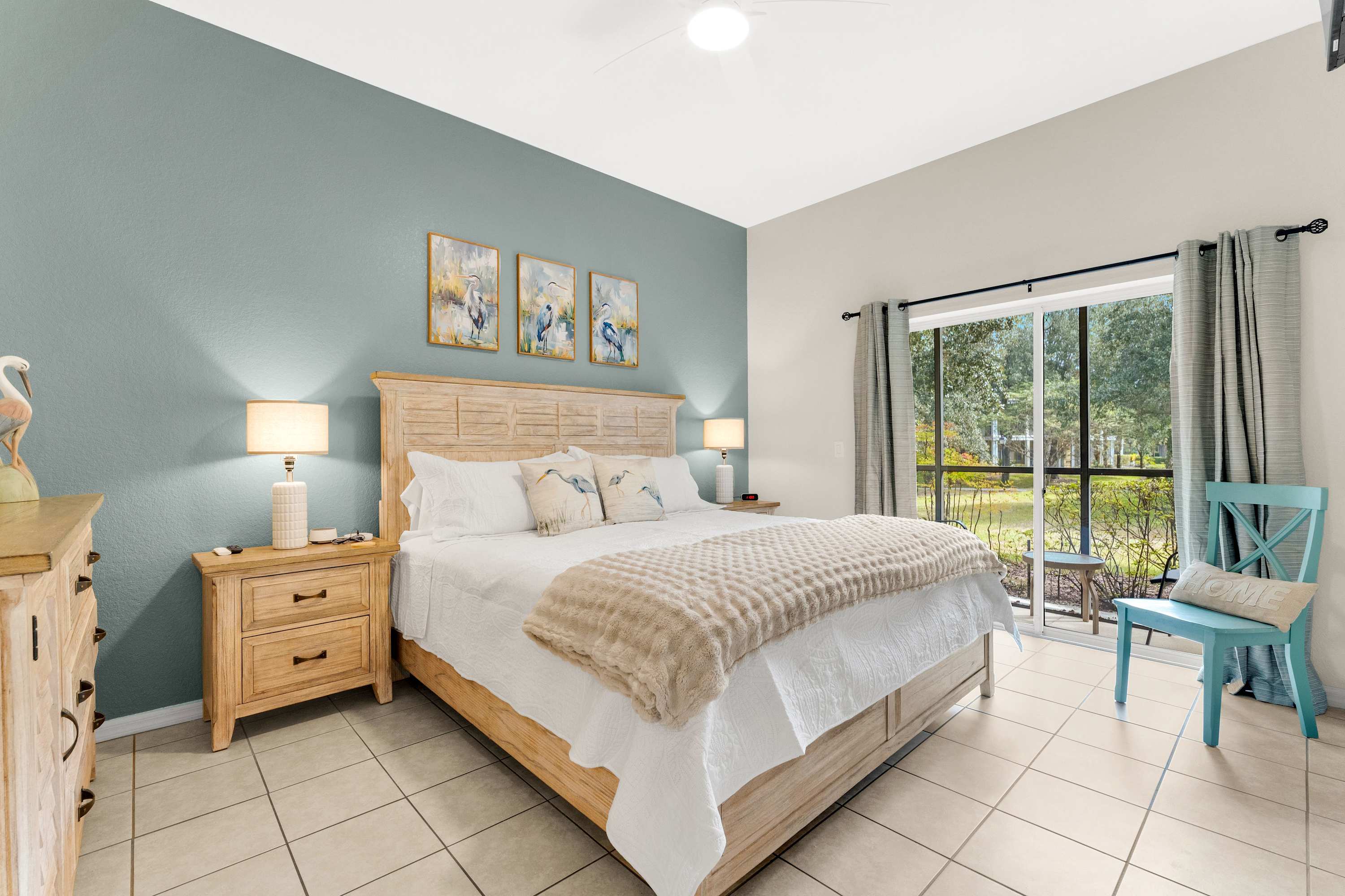 Relax in the king bedroom with a Roku Smart TV, ensuite full bathroom, and sliding-door access to the screened-in porch