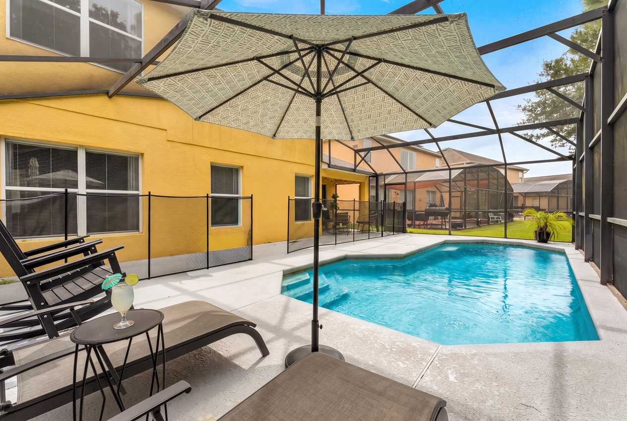 Relax by the private enclosed pool with comfortable lounge chairs