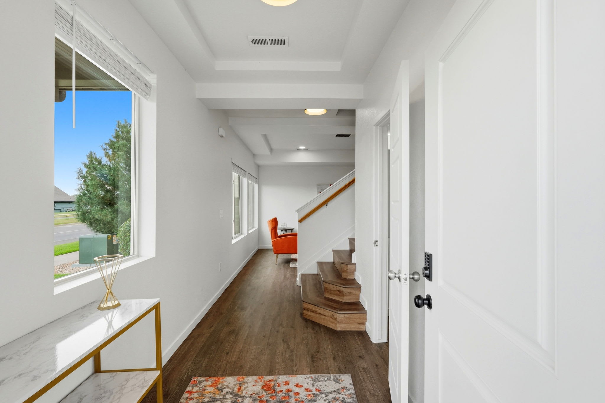 Bright front entry with keypad lock leading into the open living area