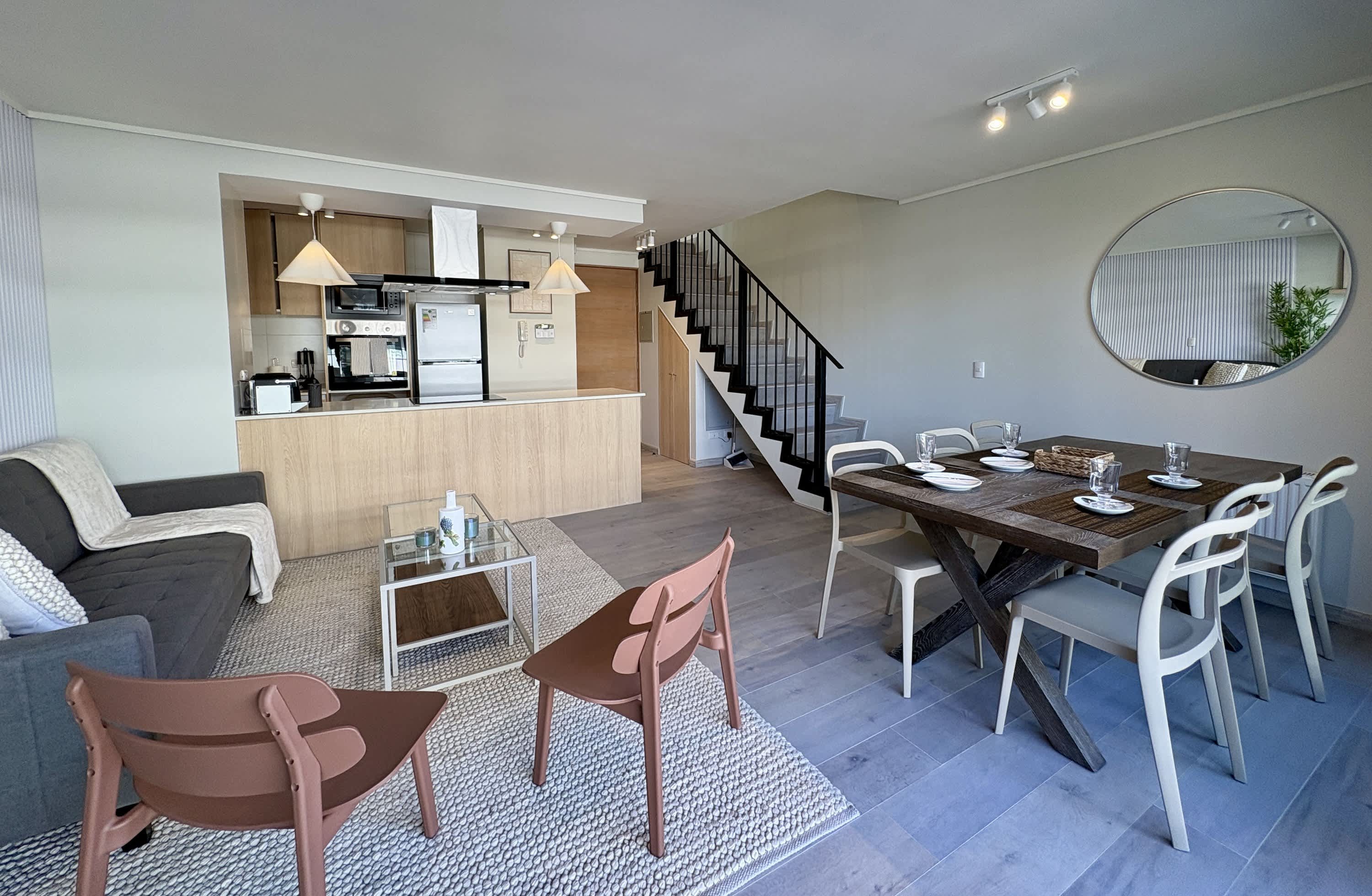Duplex living and dining area with open kitchen and interior staircase