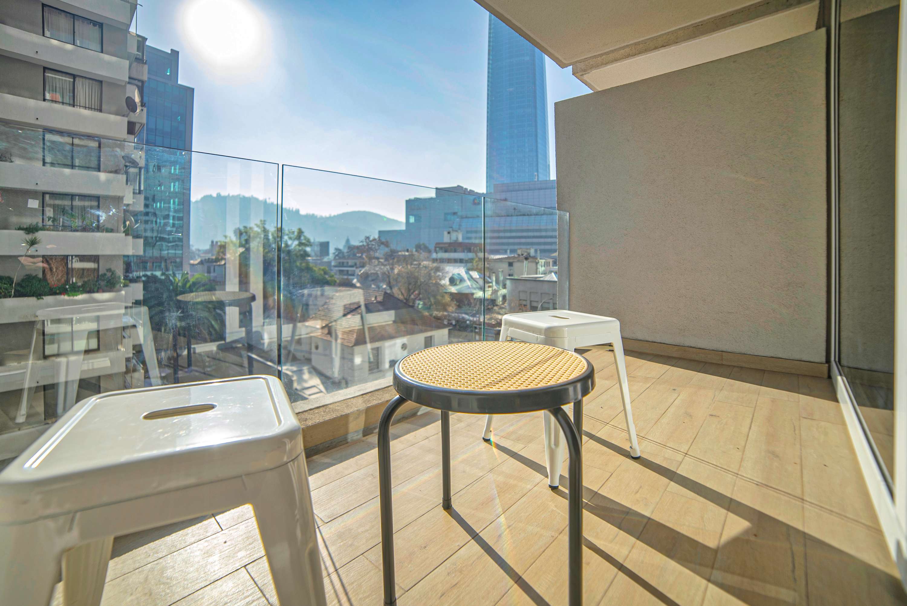 Private balcony with seating for two and sweeping views of Santiago’s skyline and mountain ridge.