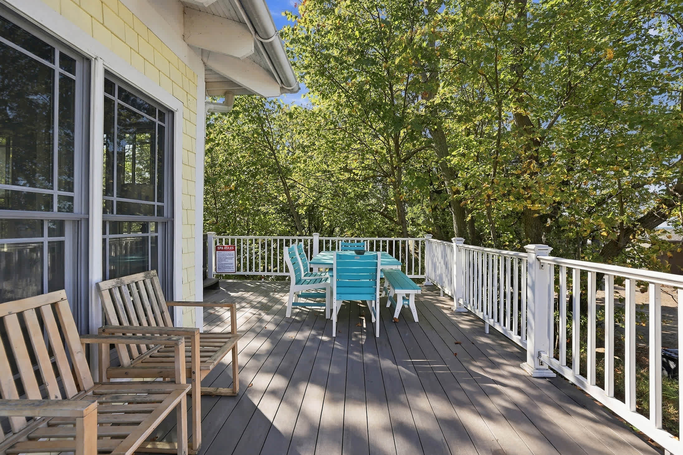 Spacious deck with dining table, bench seating, and chairs for lounging.
