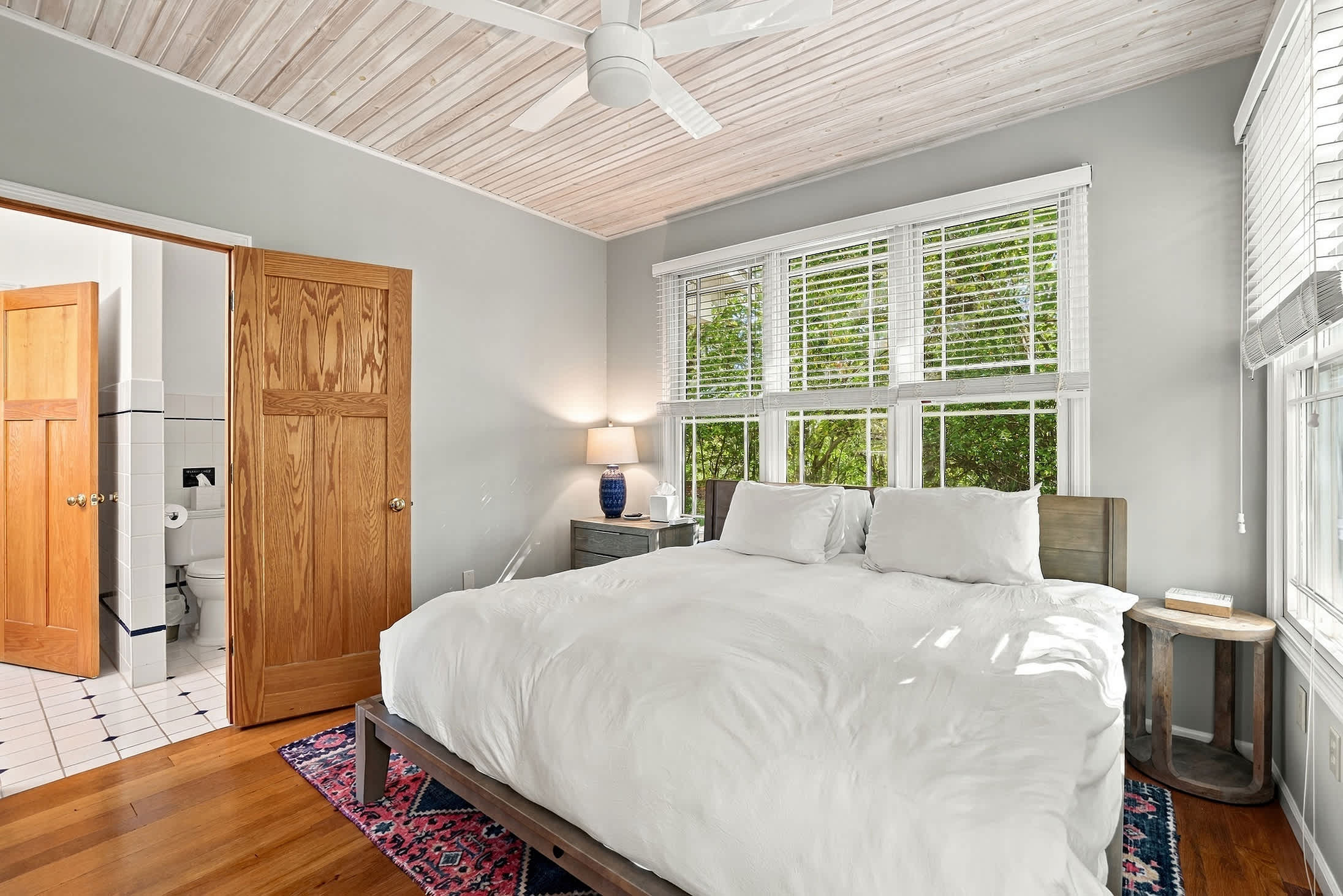 Harbor Country master bedroom with private bath, ceiling fan, and natural light.