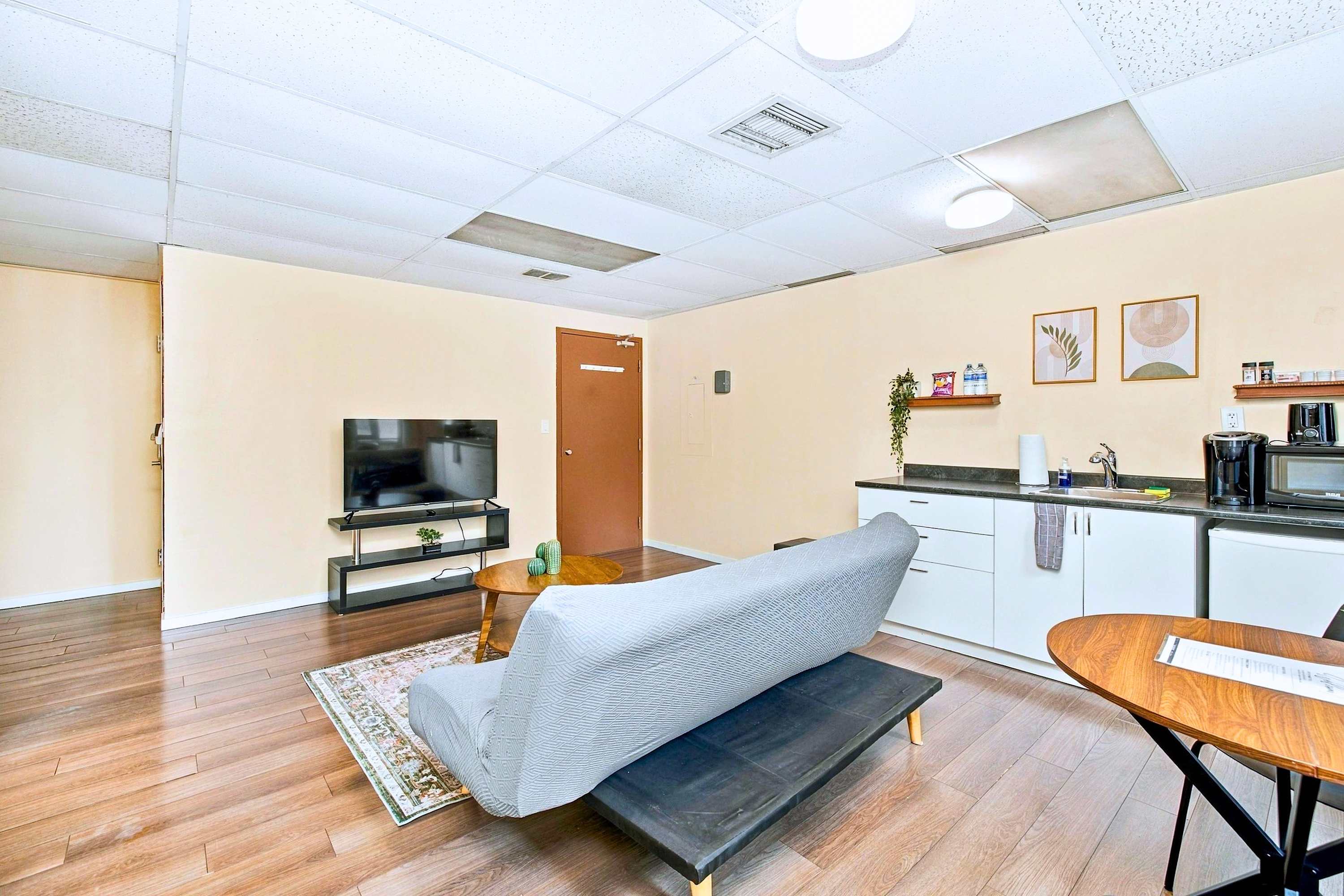 All-in-one living space with TV lounge, sofa bed, dining, and kitchen.