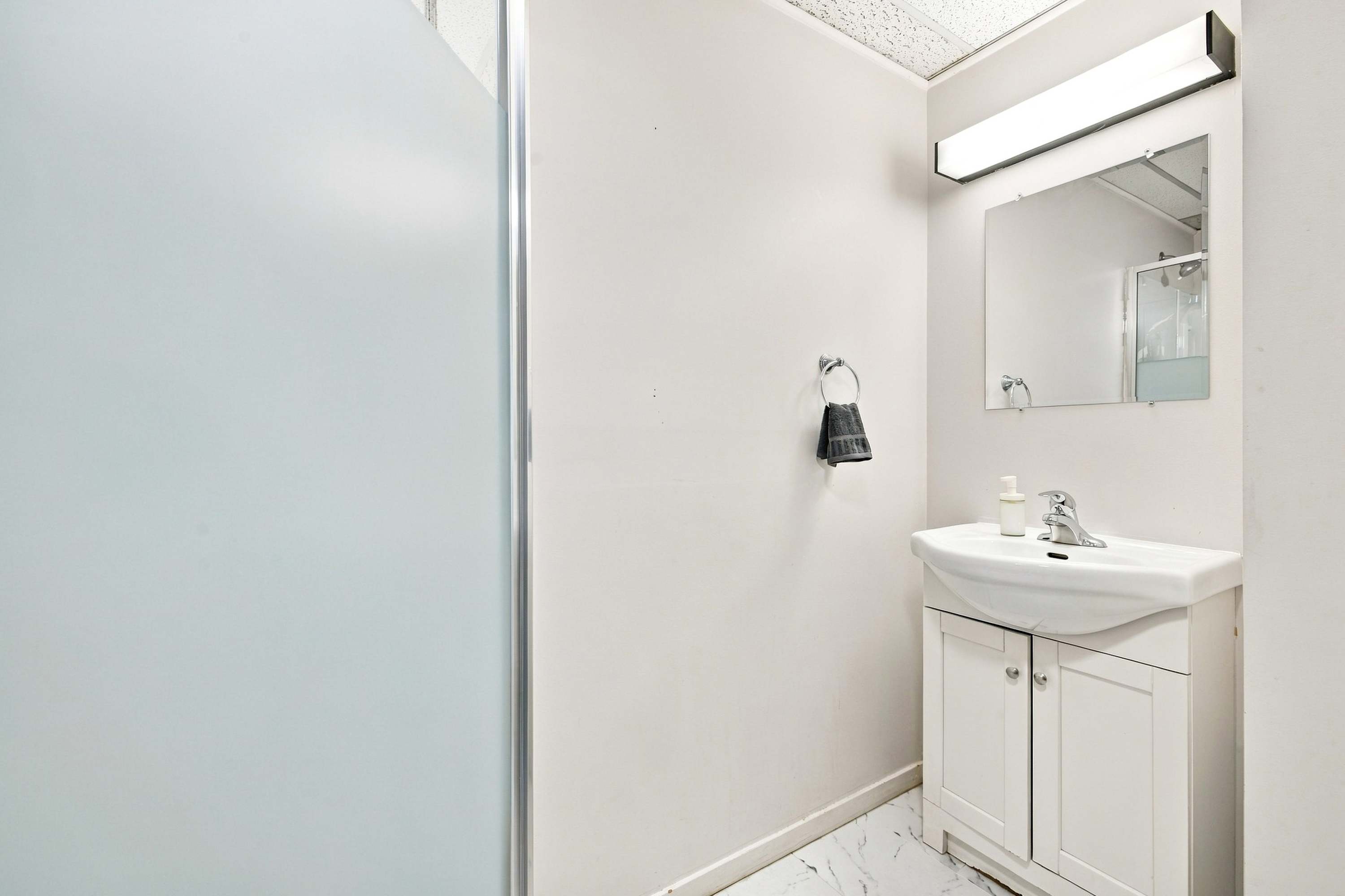 Clean, modern bath setup complete with shower, sink, and mirror.