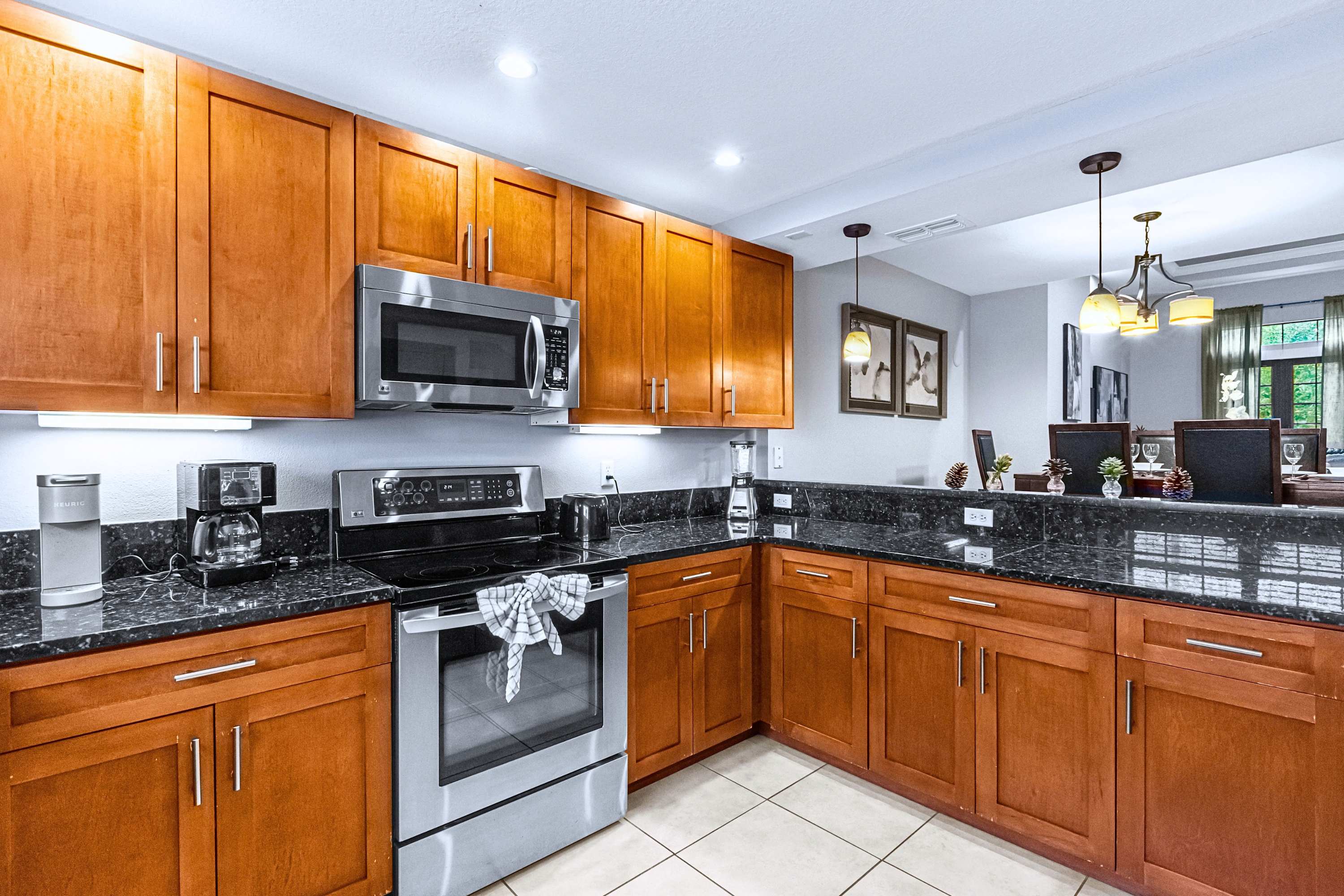 A modern, fully equipped kitchen featuring sleek granite countertops