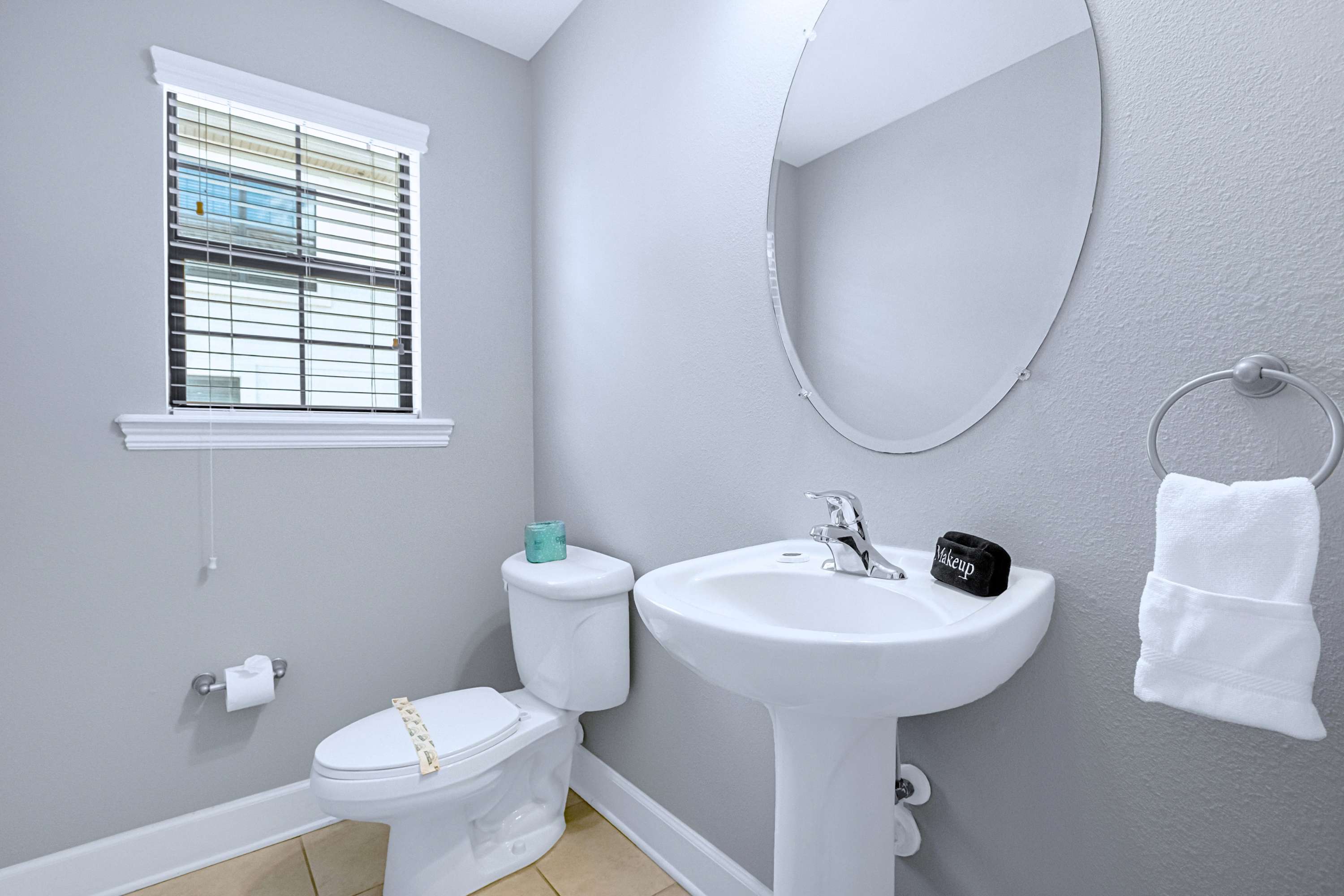 A pristine bathroom sink vanity stocked with freshly rolled towels