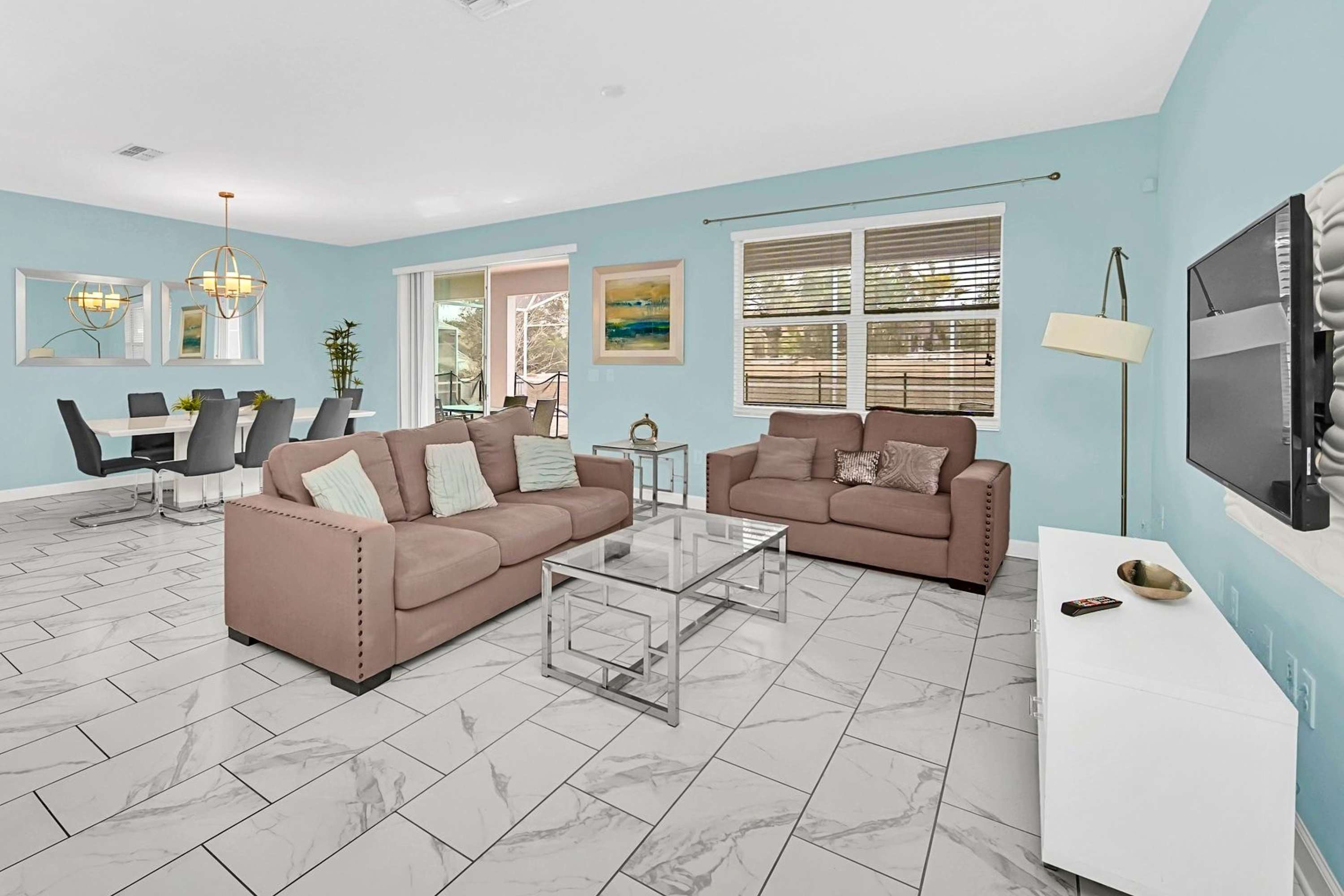 Spacious living room with comfortable sofas and large TV display.