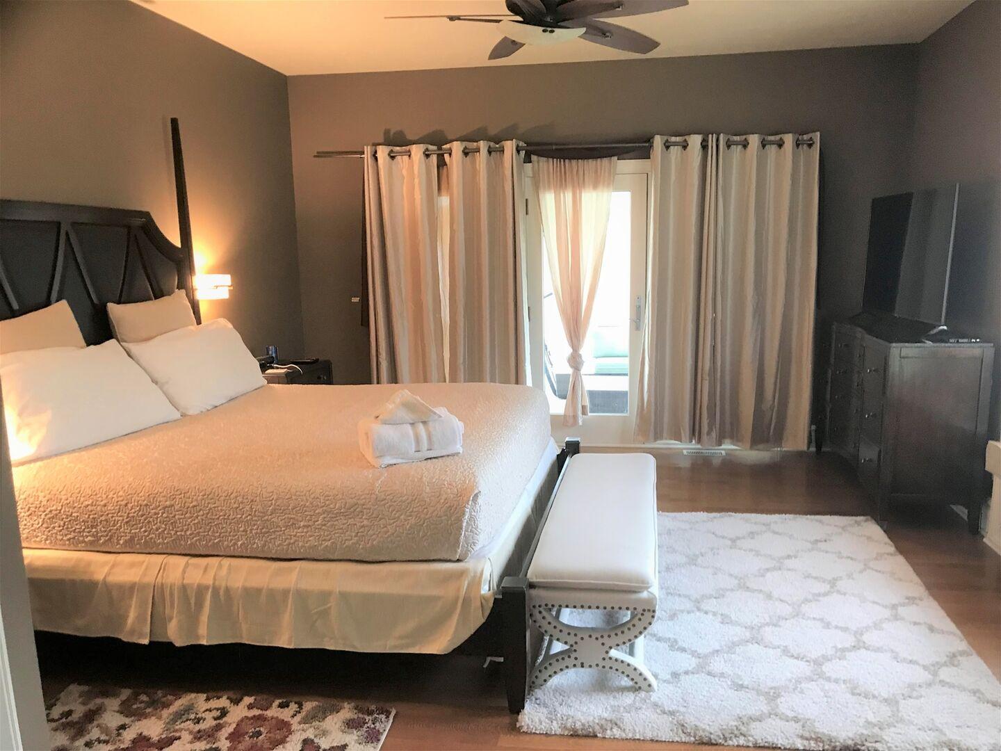 Primary king bedroom with soft lighting and a seating area