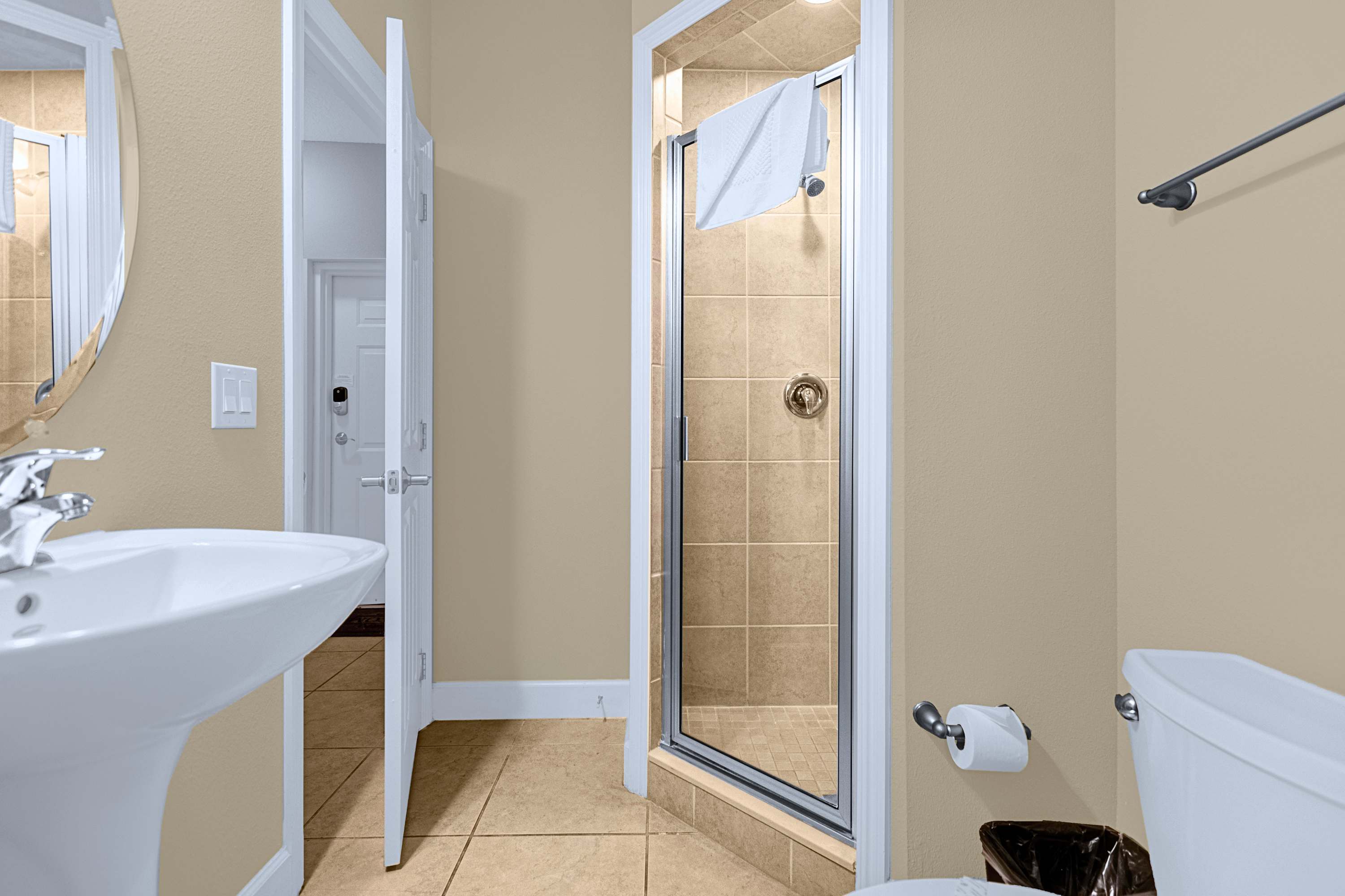 A sleek en-suite bathroom showcasing modern tile finishes and glass doors