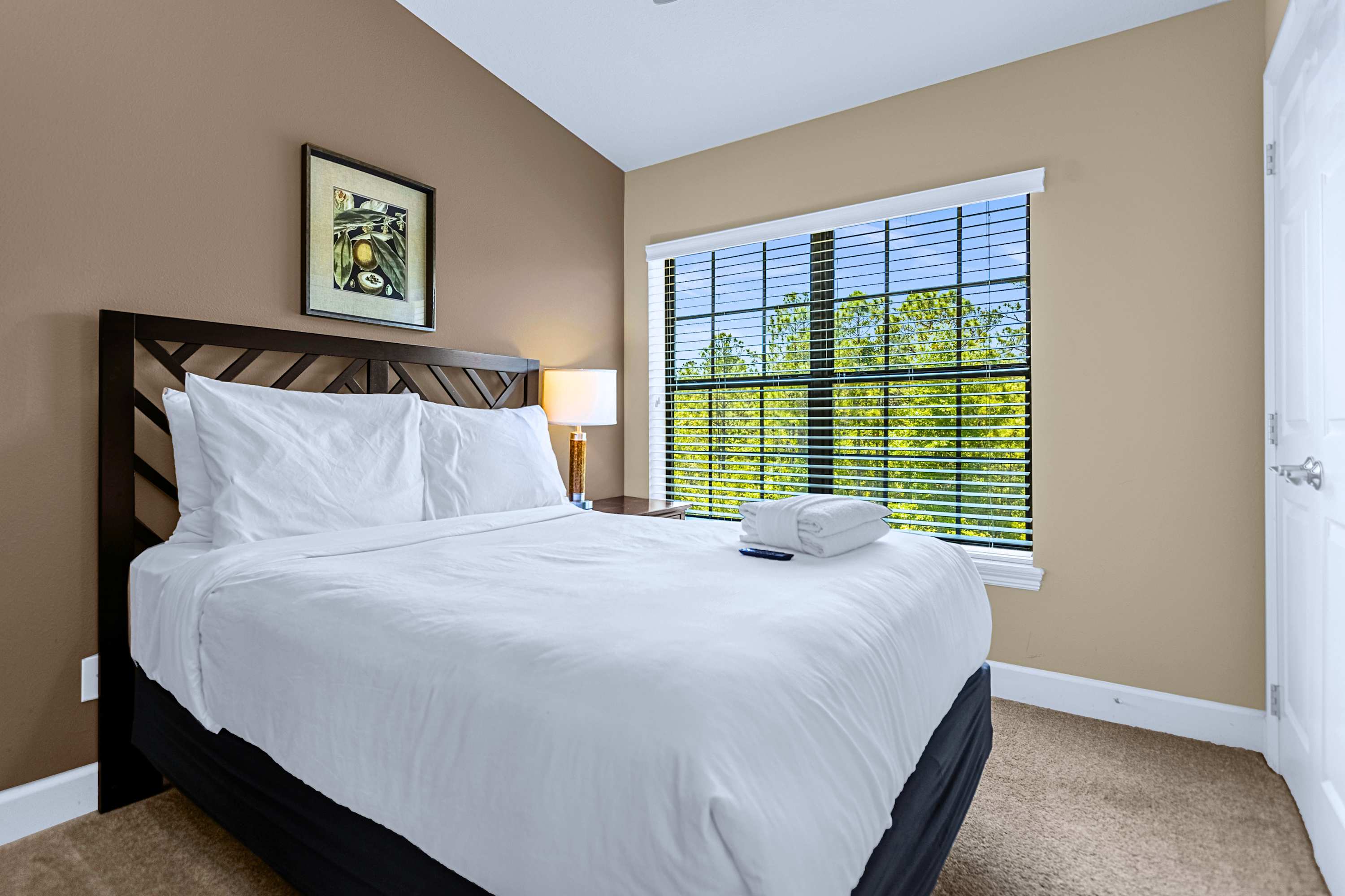 A calm guest bedroom styled with minimal decor and crisp white linens