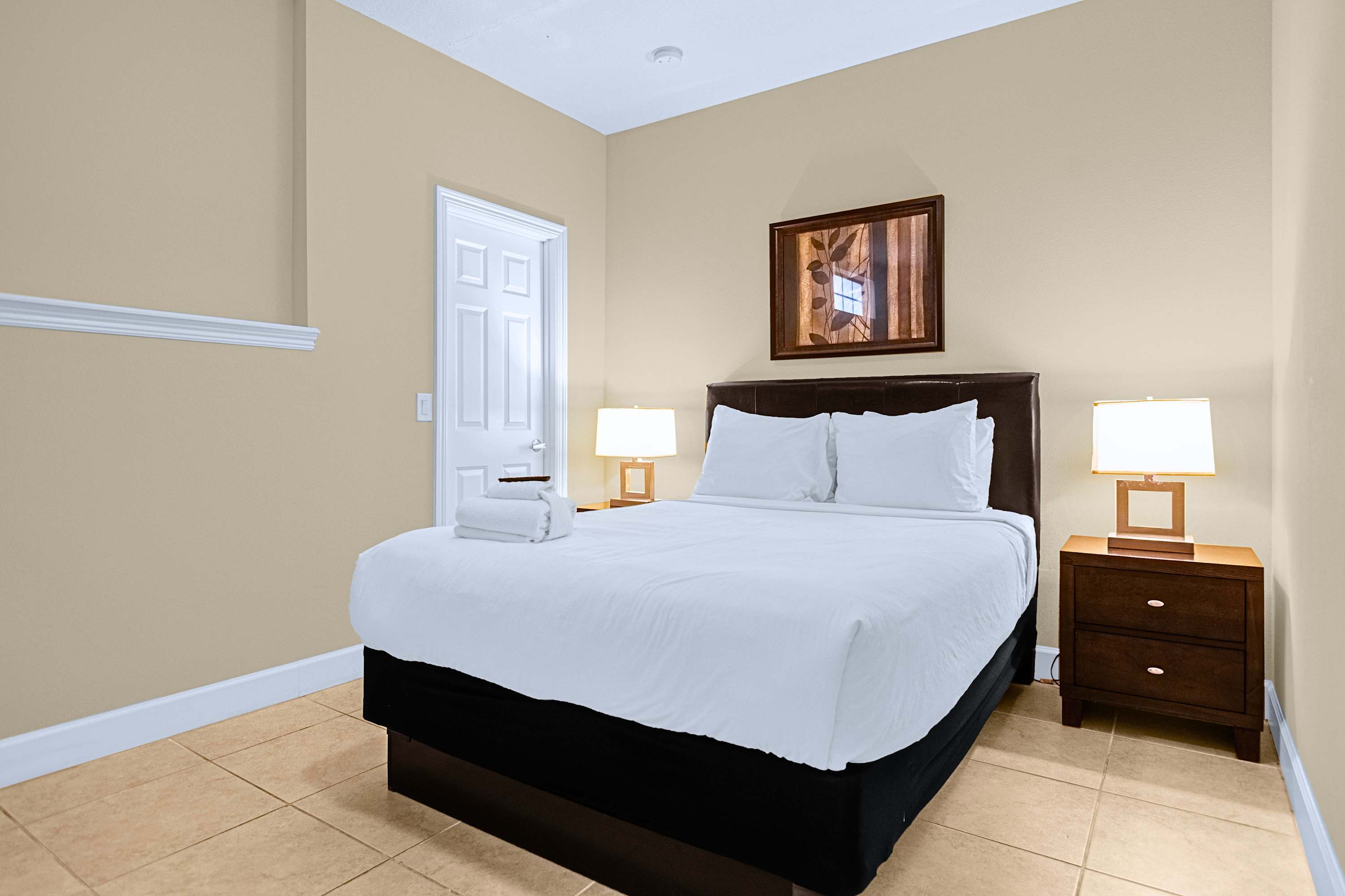Restful guest room featuring a plush mattress and warm bedside lighting