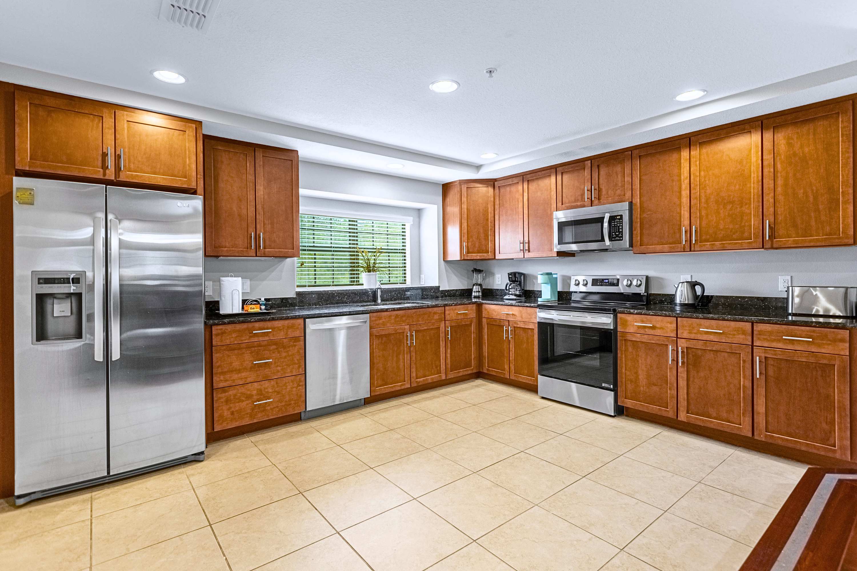 A modern, fully equipped kitchen featuring sleek granite countertops