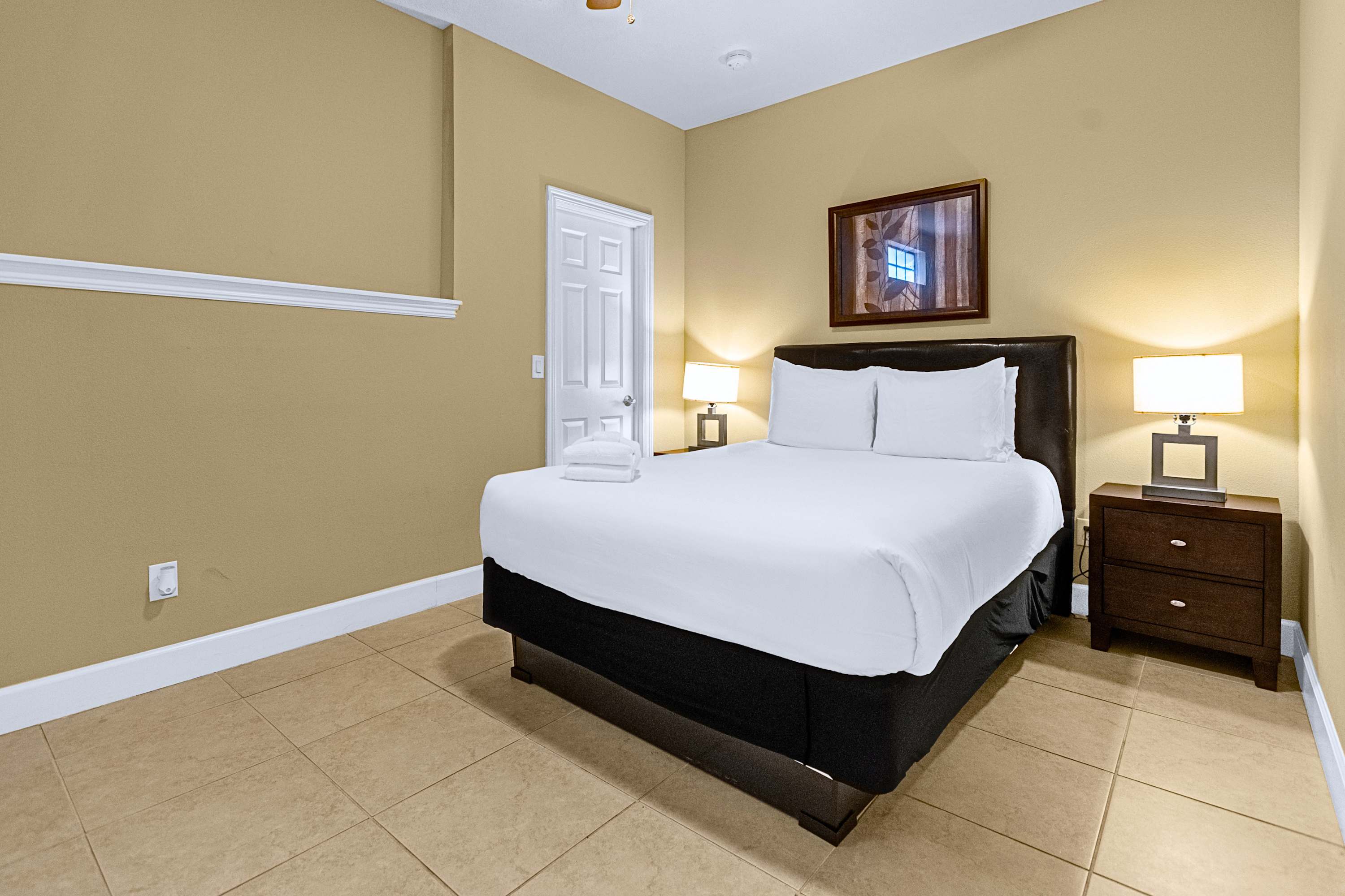 Restful guest room featuring a plush mattress and warm bedside lighting