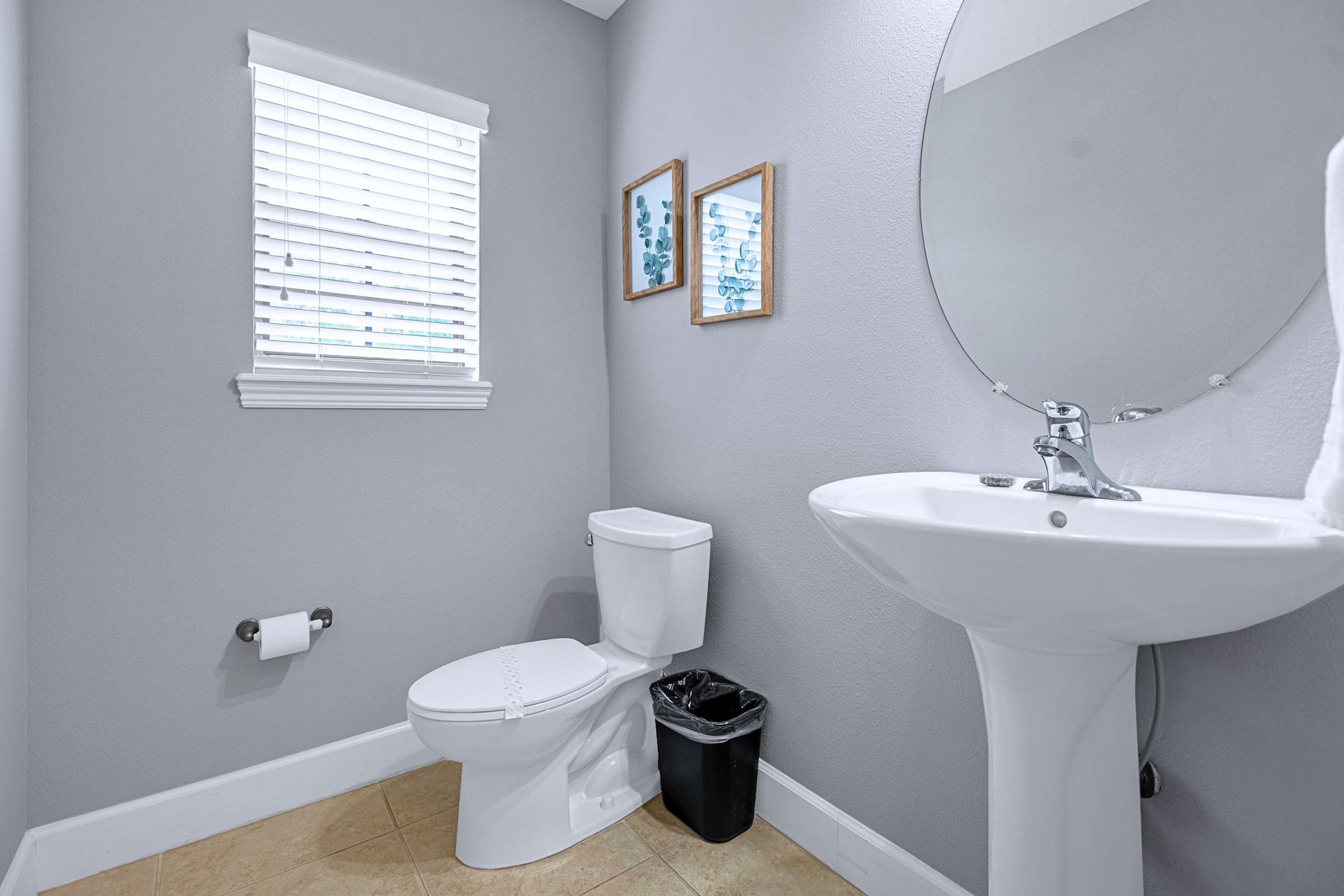 A pristine bathroom sink vanity stocked with freshly rolled towels