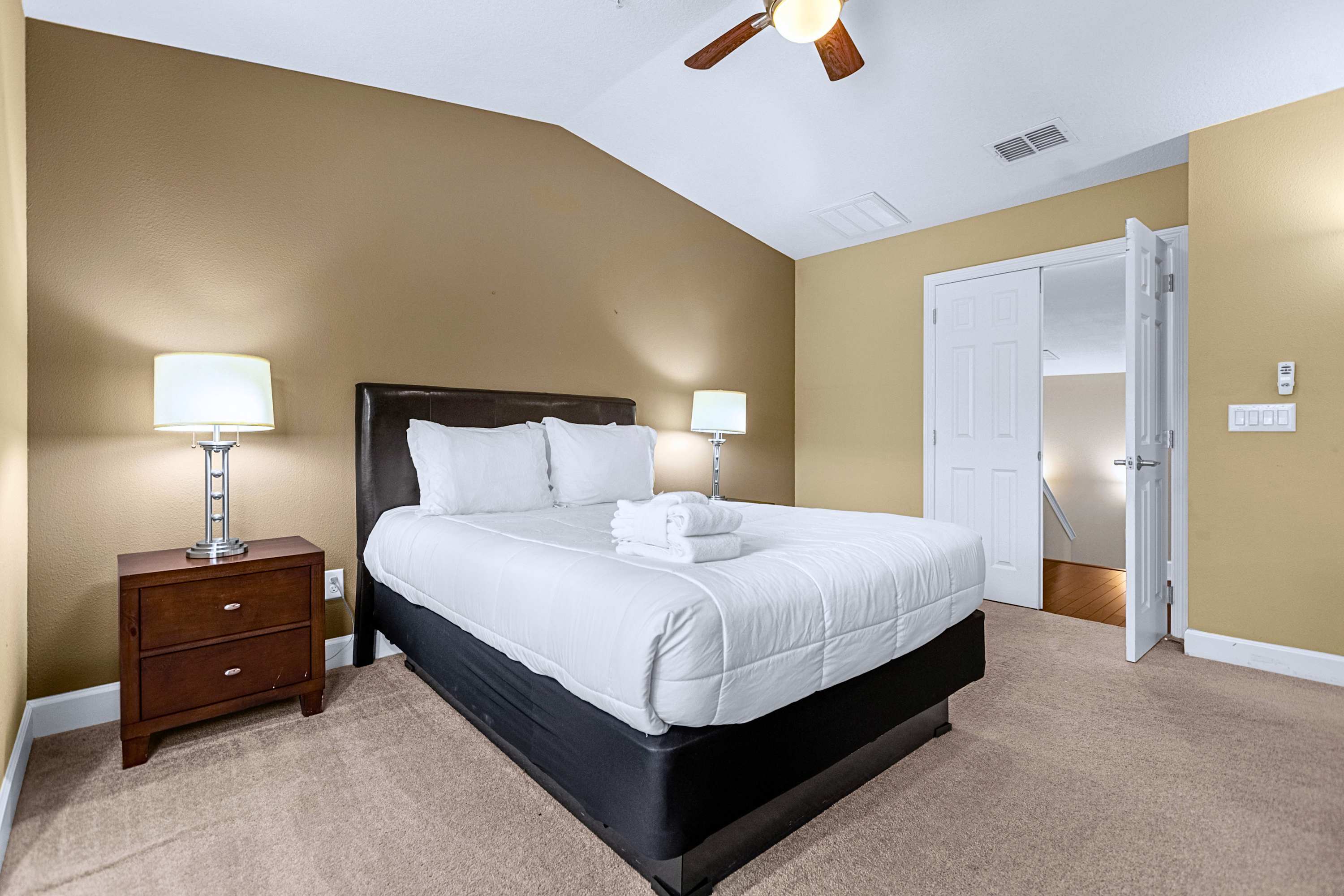 A serene sleeping sanctuary equipped with bedside lamps and dark accents