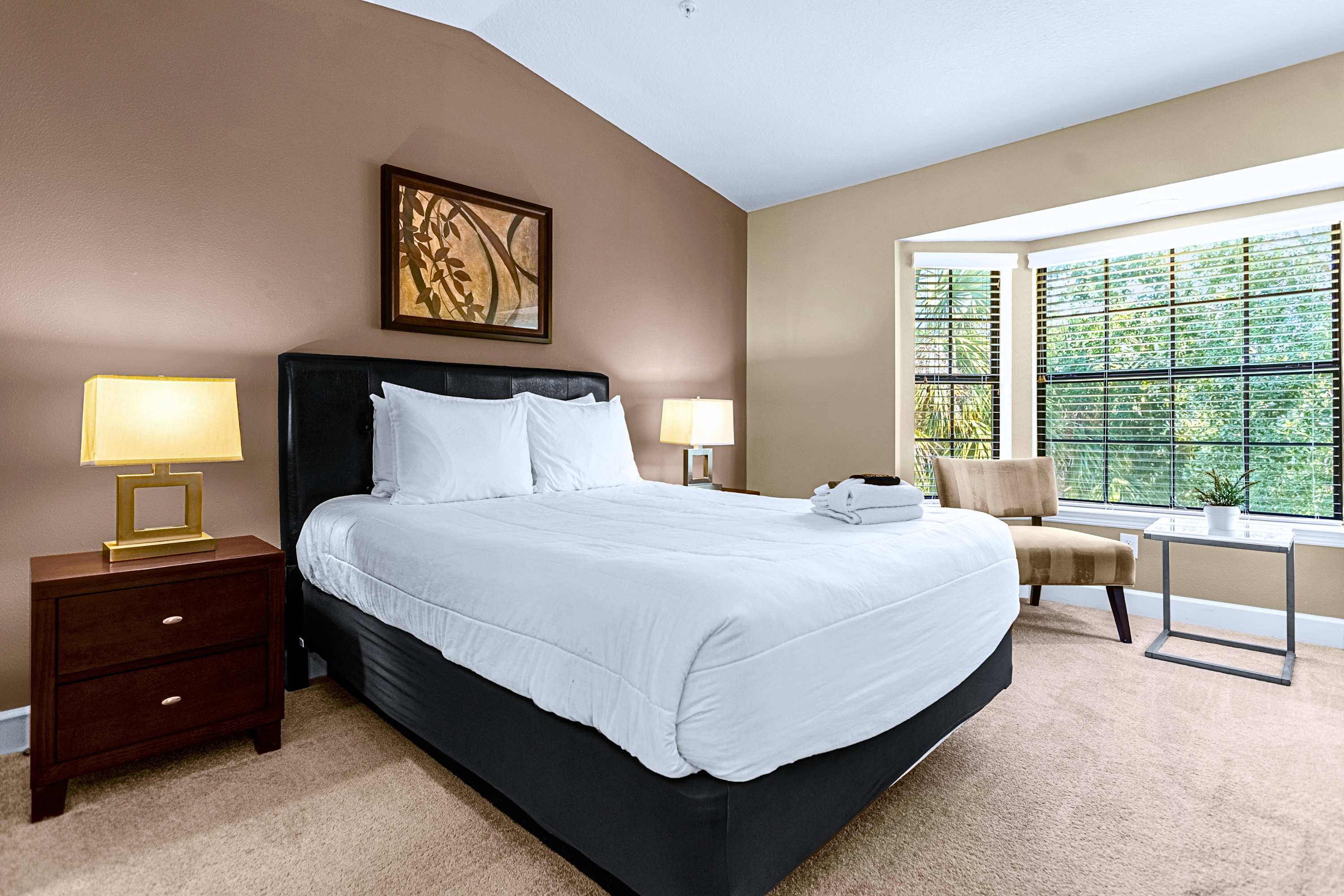 A peaceful guest bedroom featuring crisp white linens and a wall-mounted TV