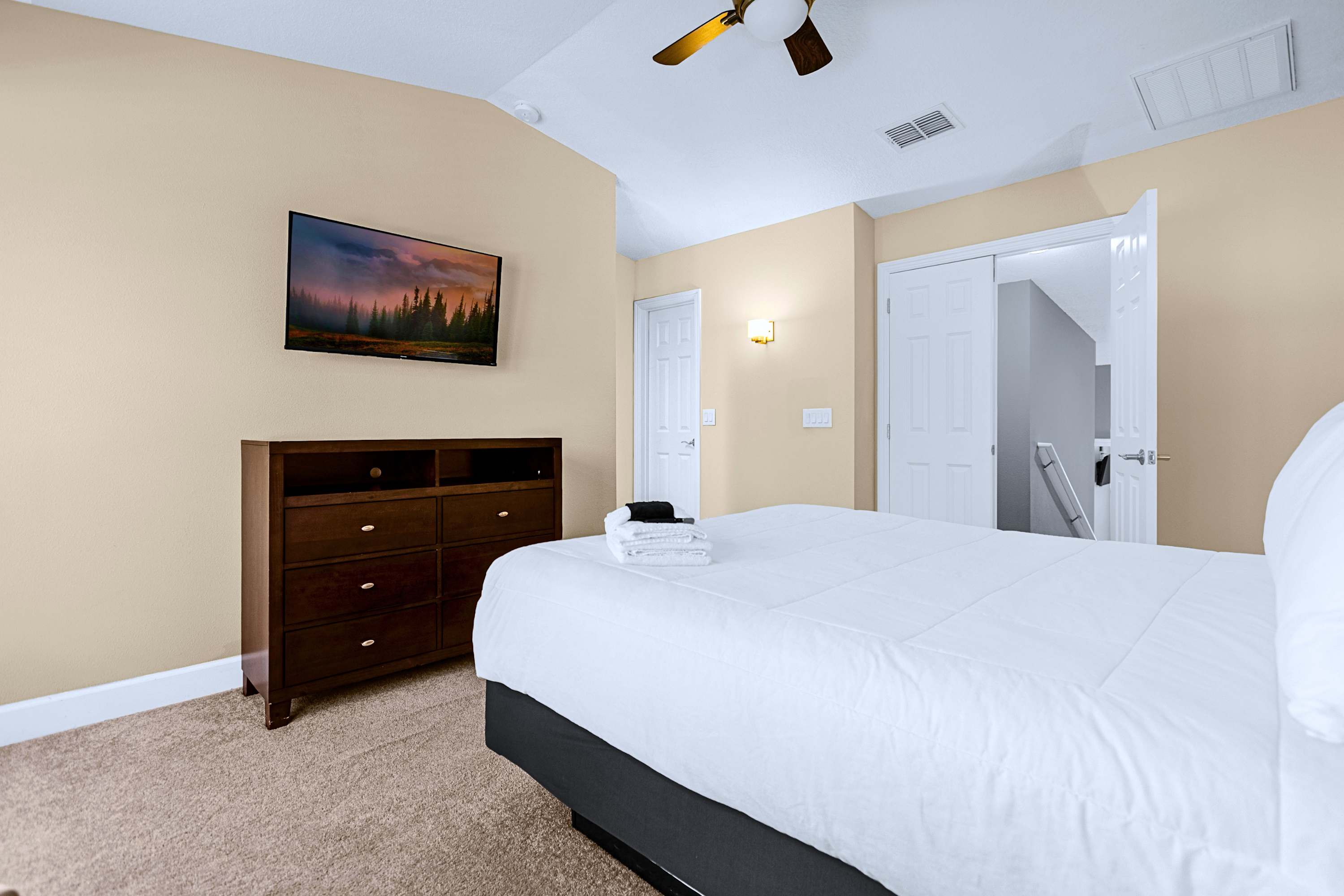 A calm guest bedroom styled with minimal decor and crisp white linens