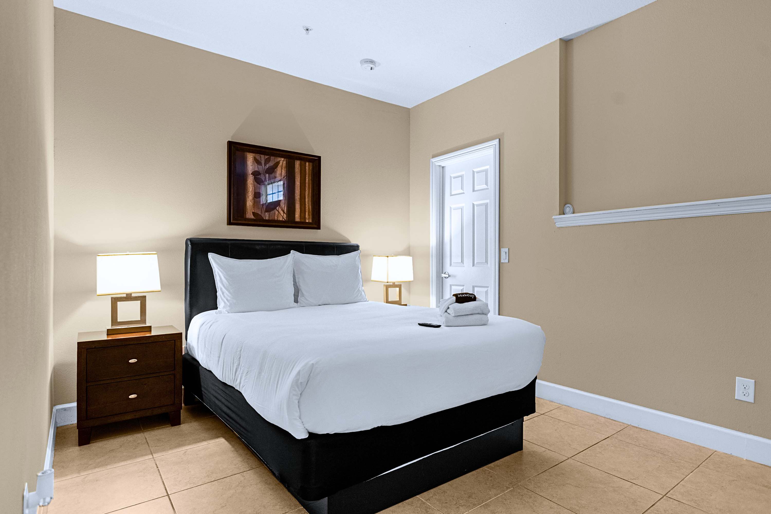A serene sleeping sanctuary equipped with bedside lamps and dark accents