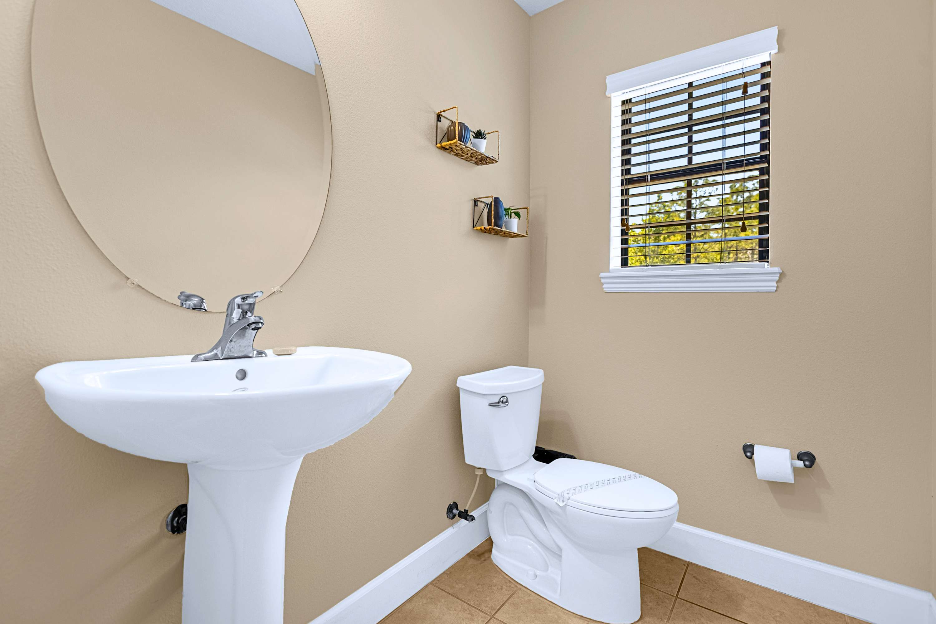 A pristine bathroom sink vanity stocked with freshly rolled towels