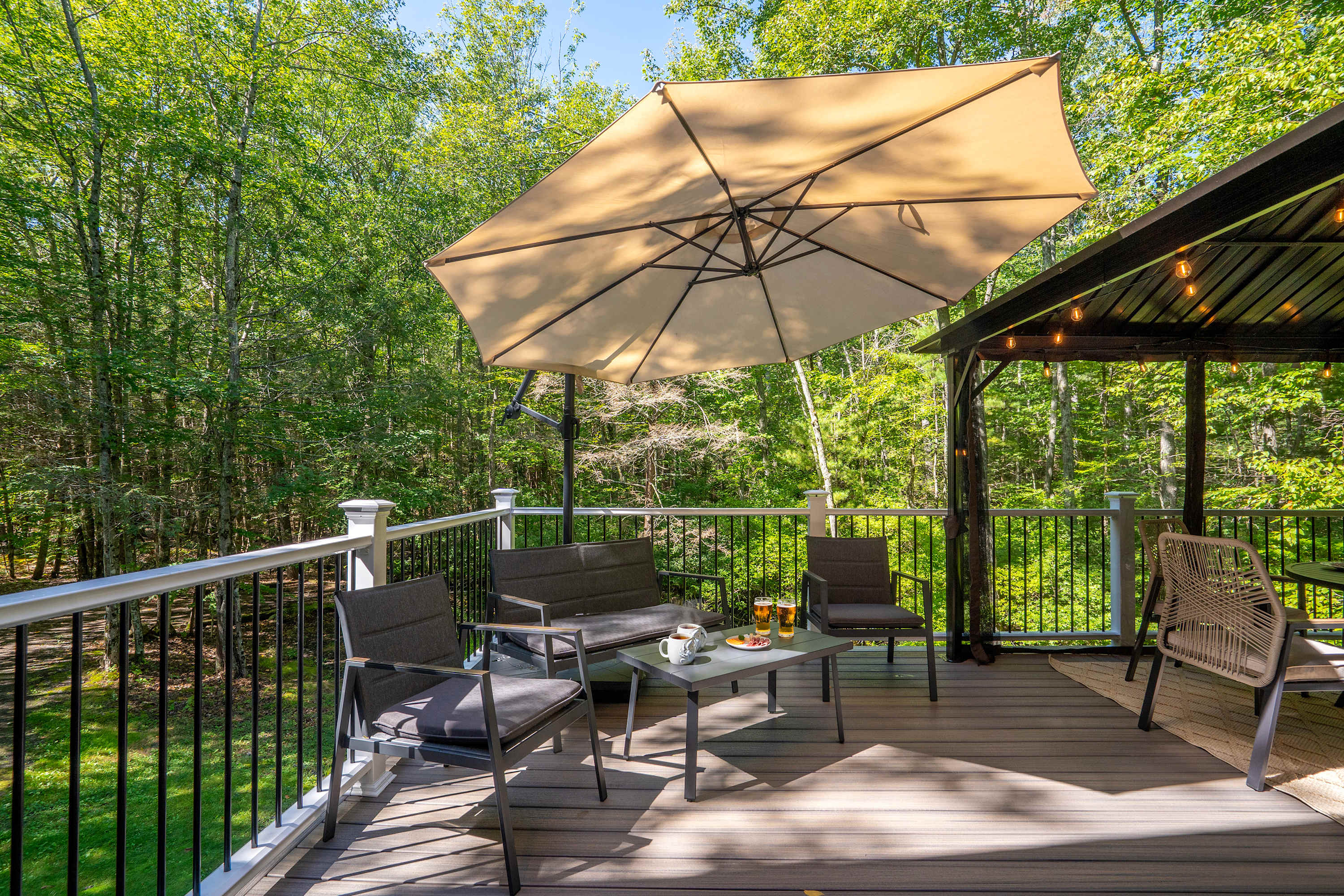 Relax among the trees on the backyard deck, complete with outdoor seating, a covered table, and BBQ