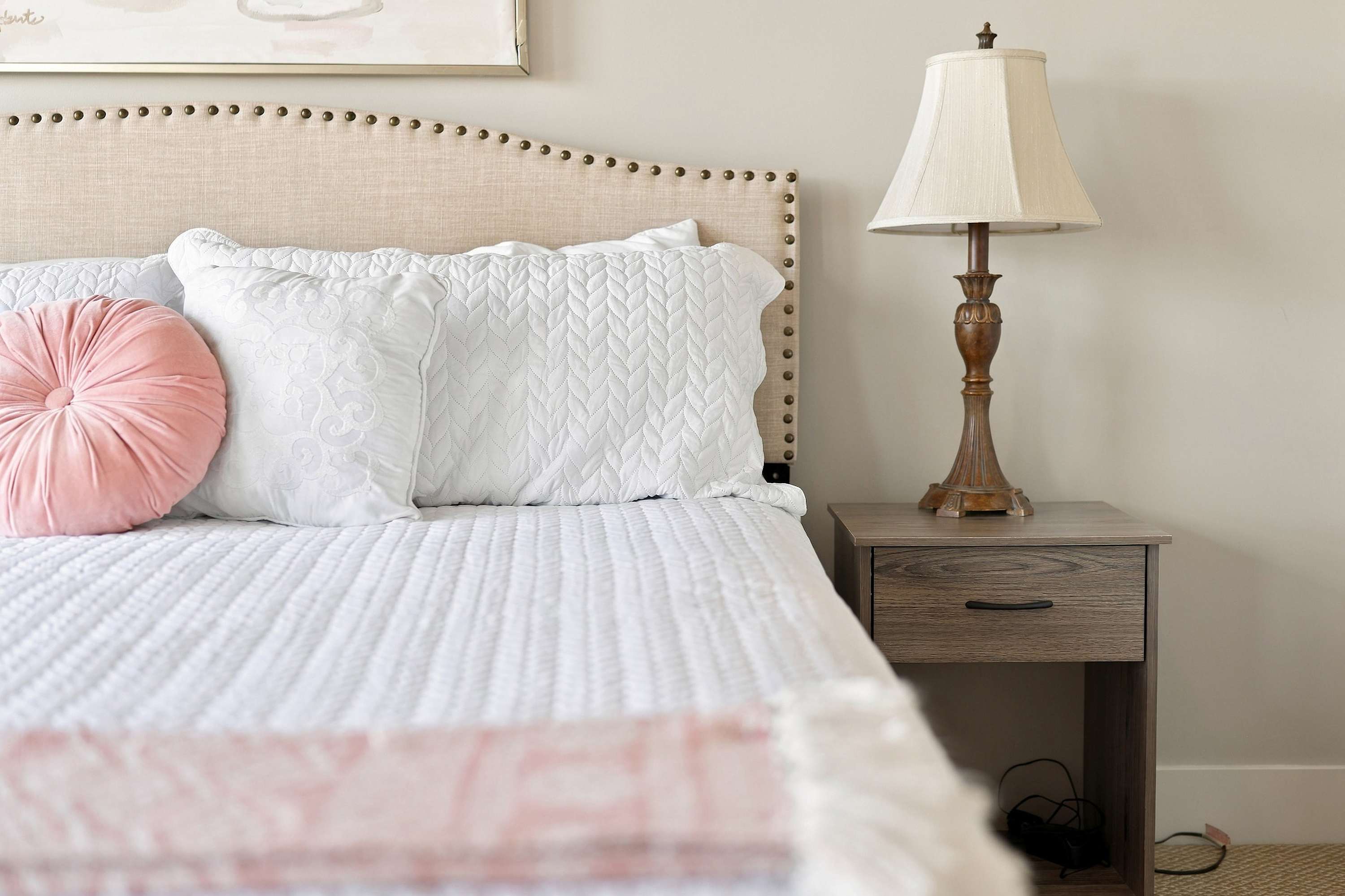 Blush pink accents and plush pillows make this bedroom a soft landing.
