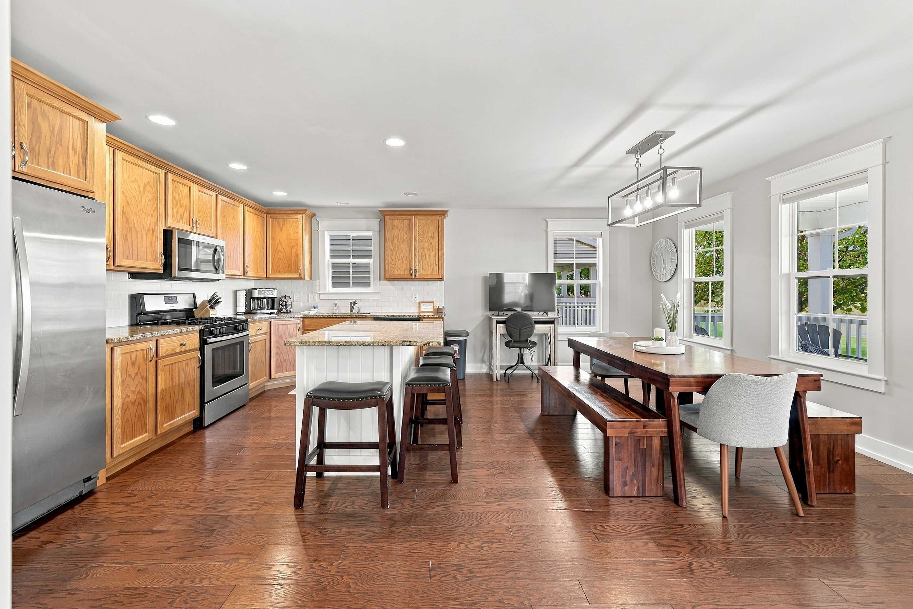 Open kitchen and dining with a granite island, gas range, and bench seating.