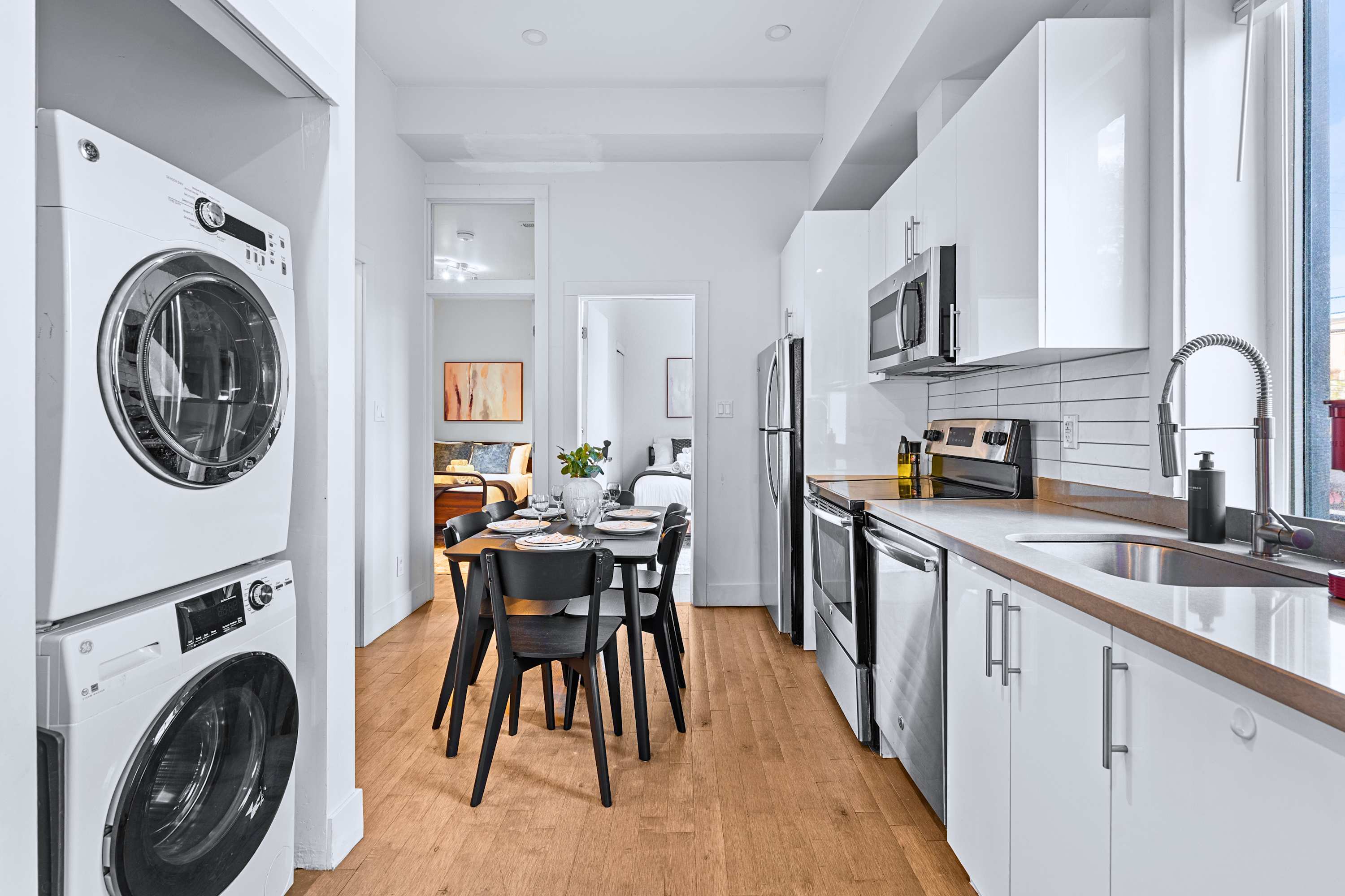 Convenient in-unit laundry area featuring a modern stacked washer and dryer