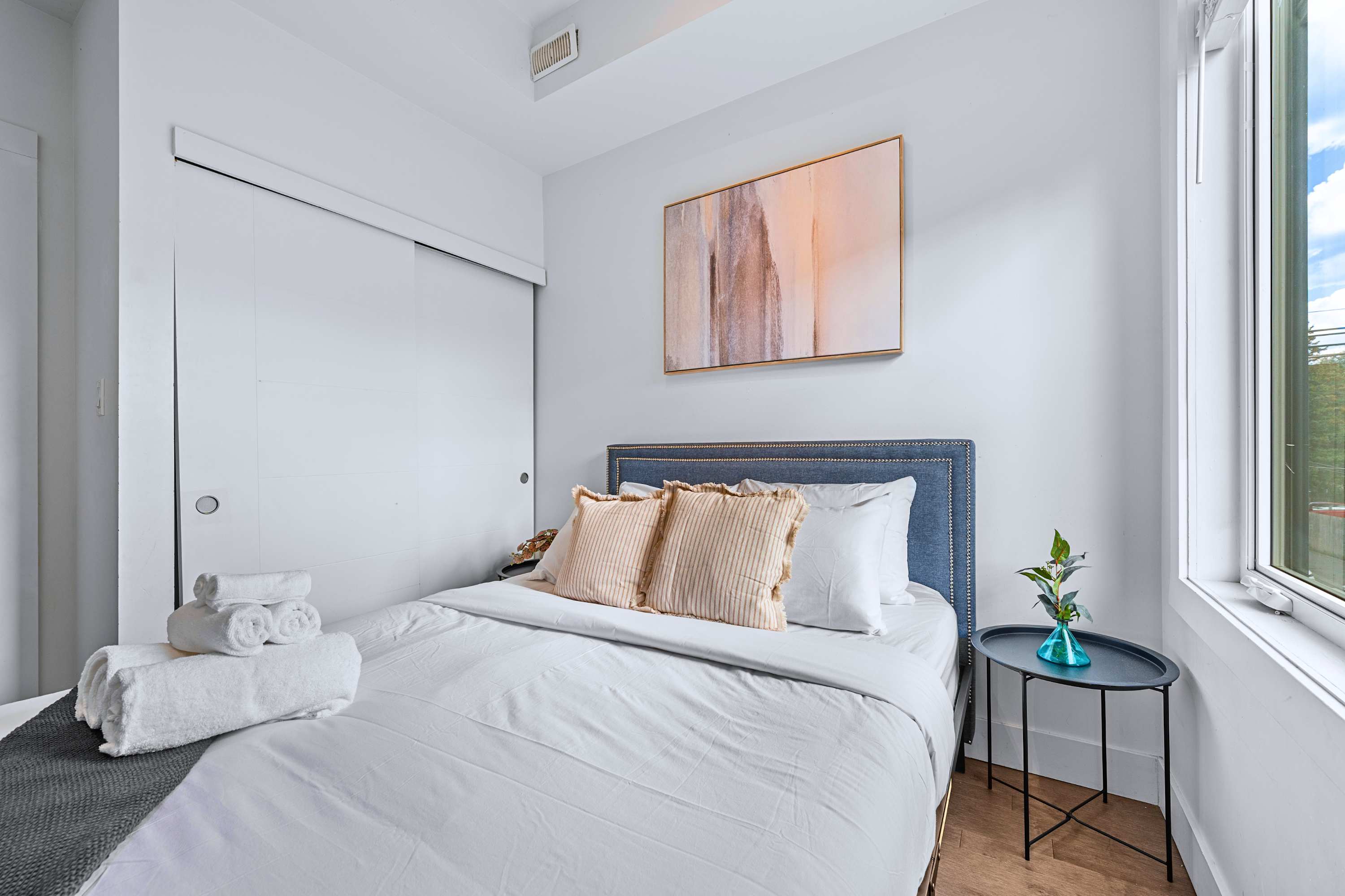 A peaceful bedroom retreat dressed in crisp white linens and neutral decor
