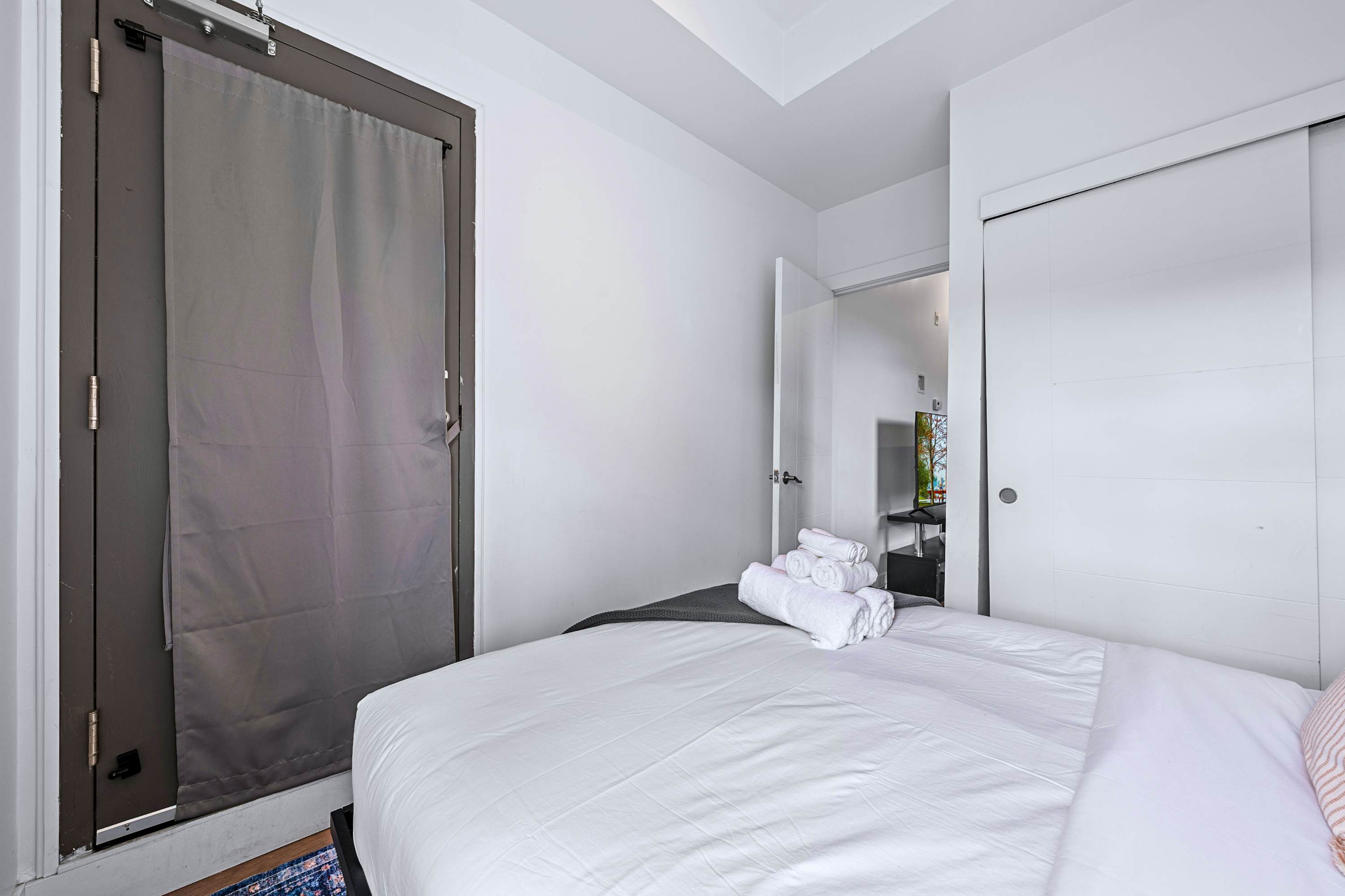 A tranquil sleeping space featuring a closet alcove and soft natural lighting