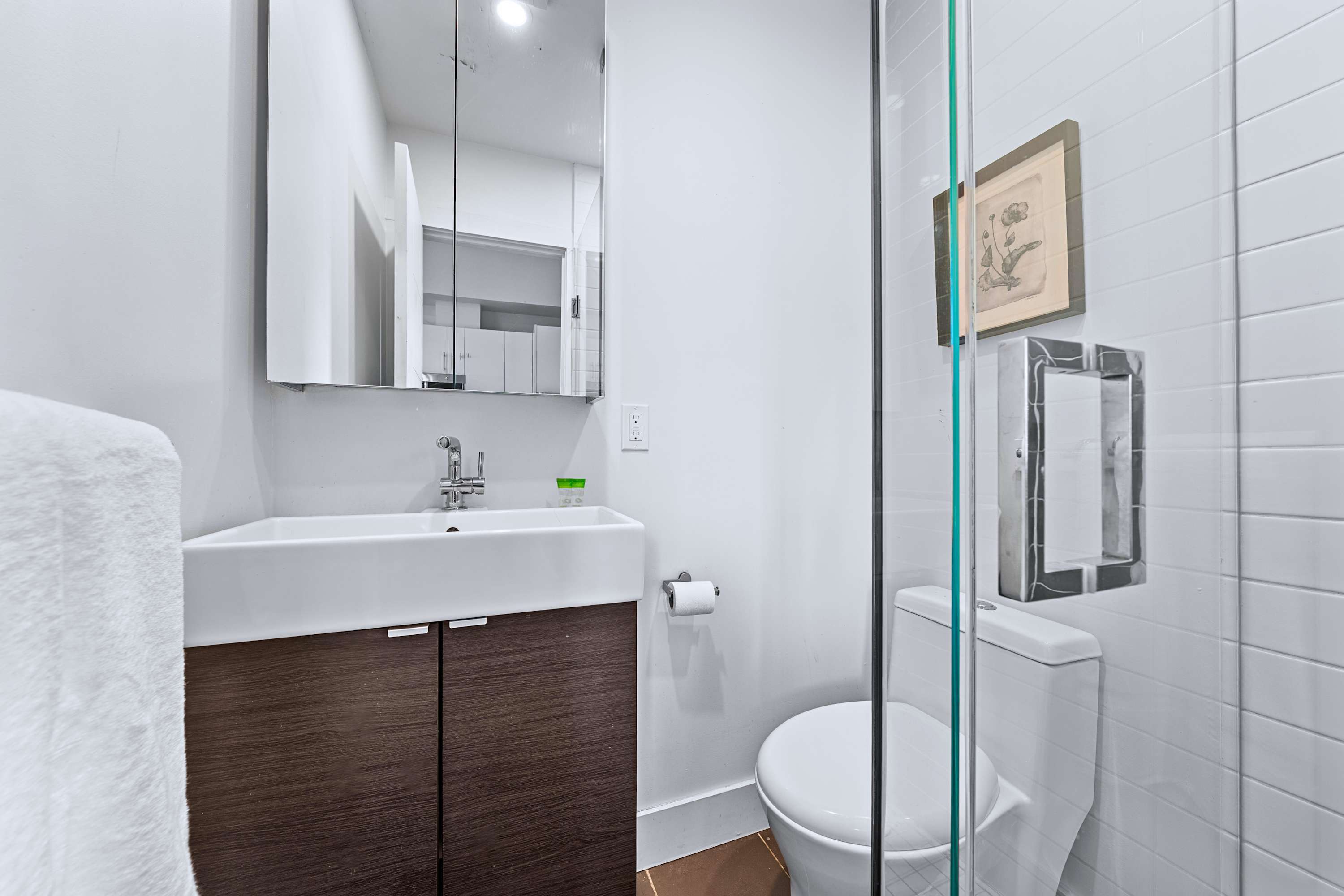 A sleek en-suite bathroom showcasing modern tile finishes and glass doors