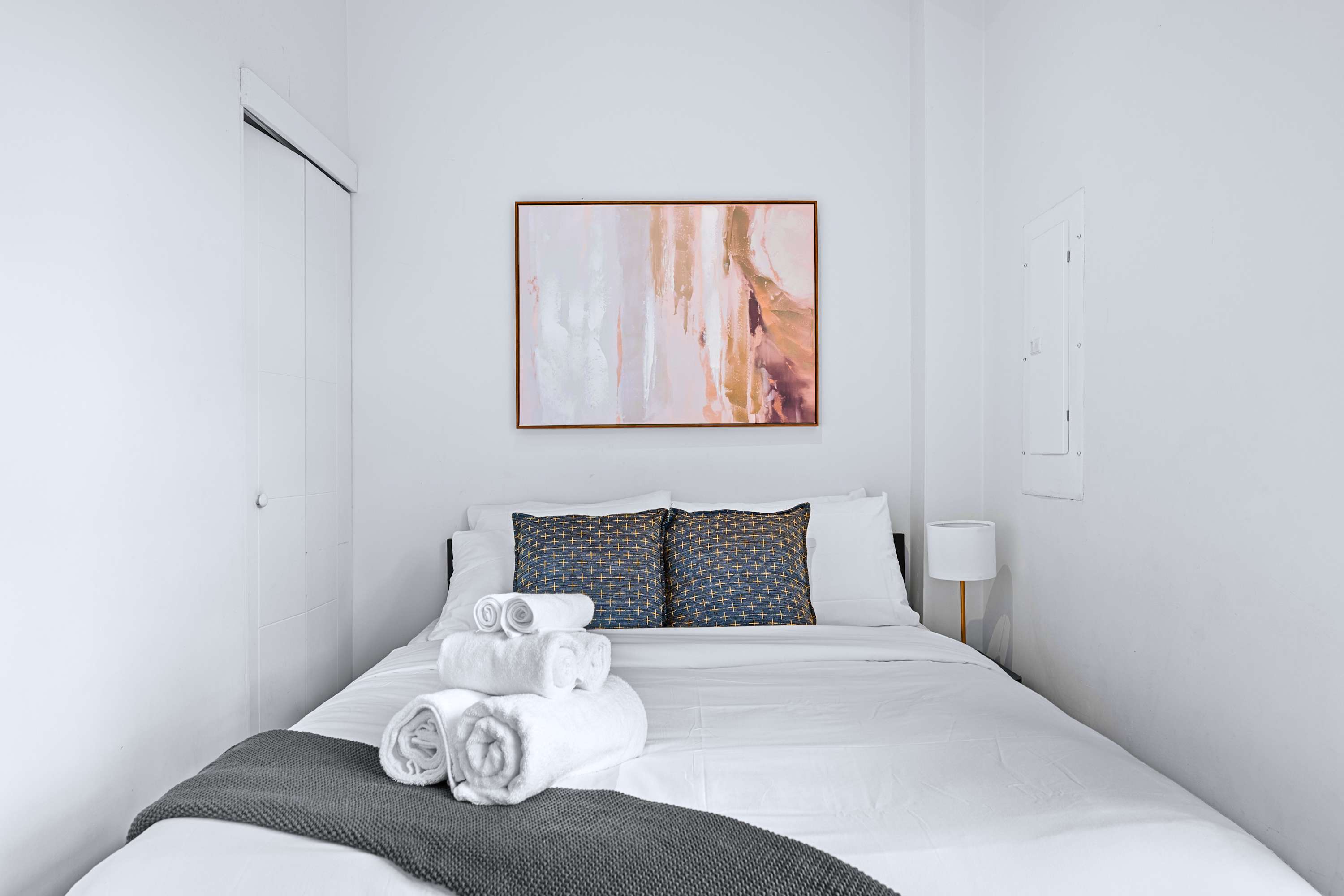A peaceful guest room setup offering built-in closet storage and light decor