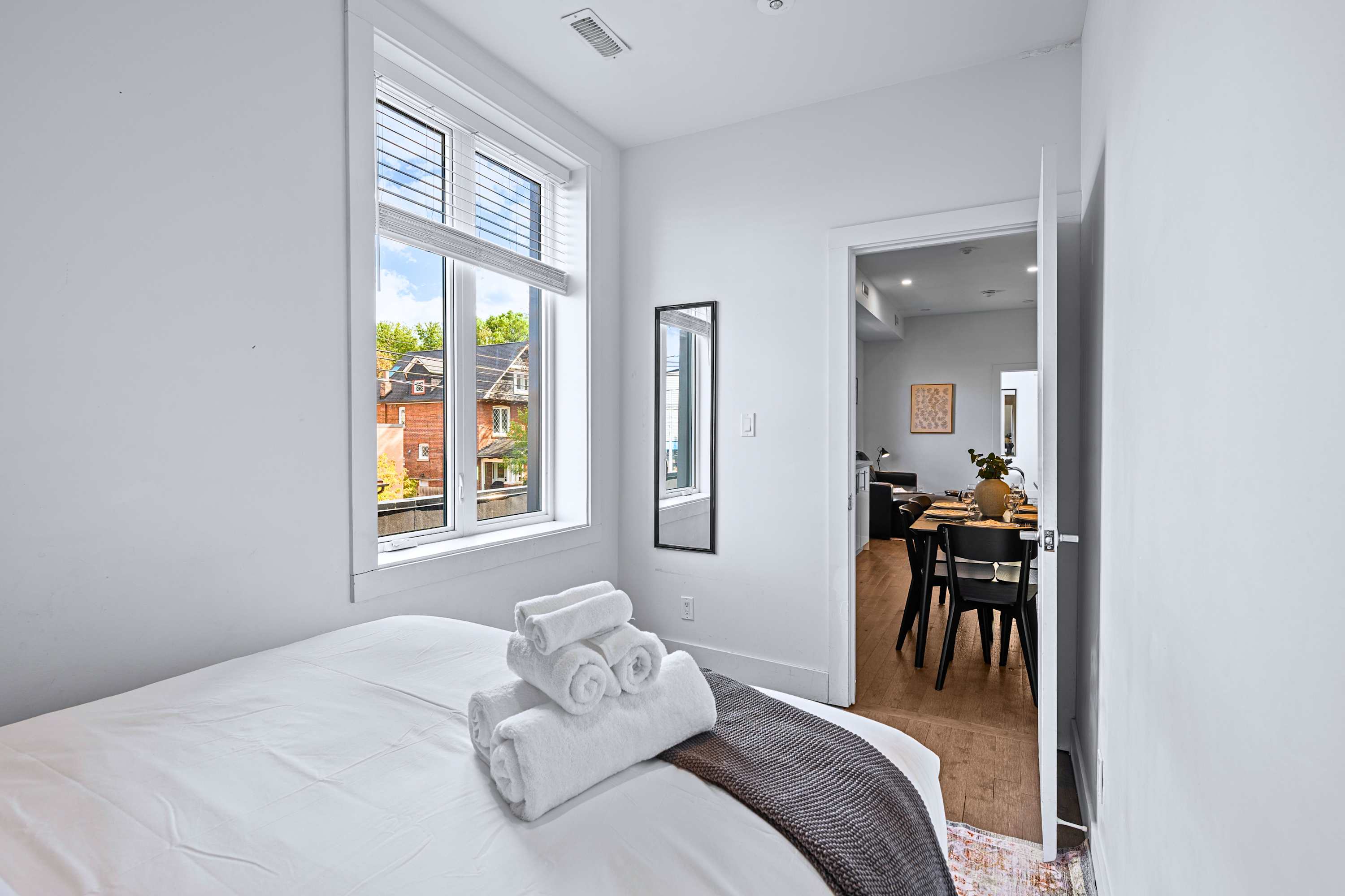 A light-filled guest bedroom offering peaceful street views through big windows