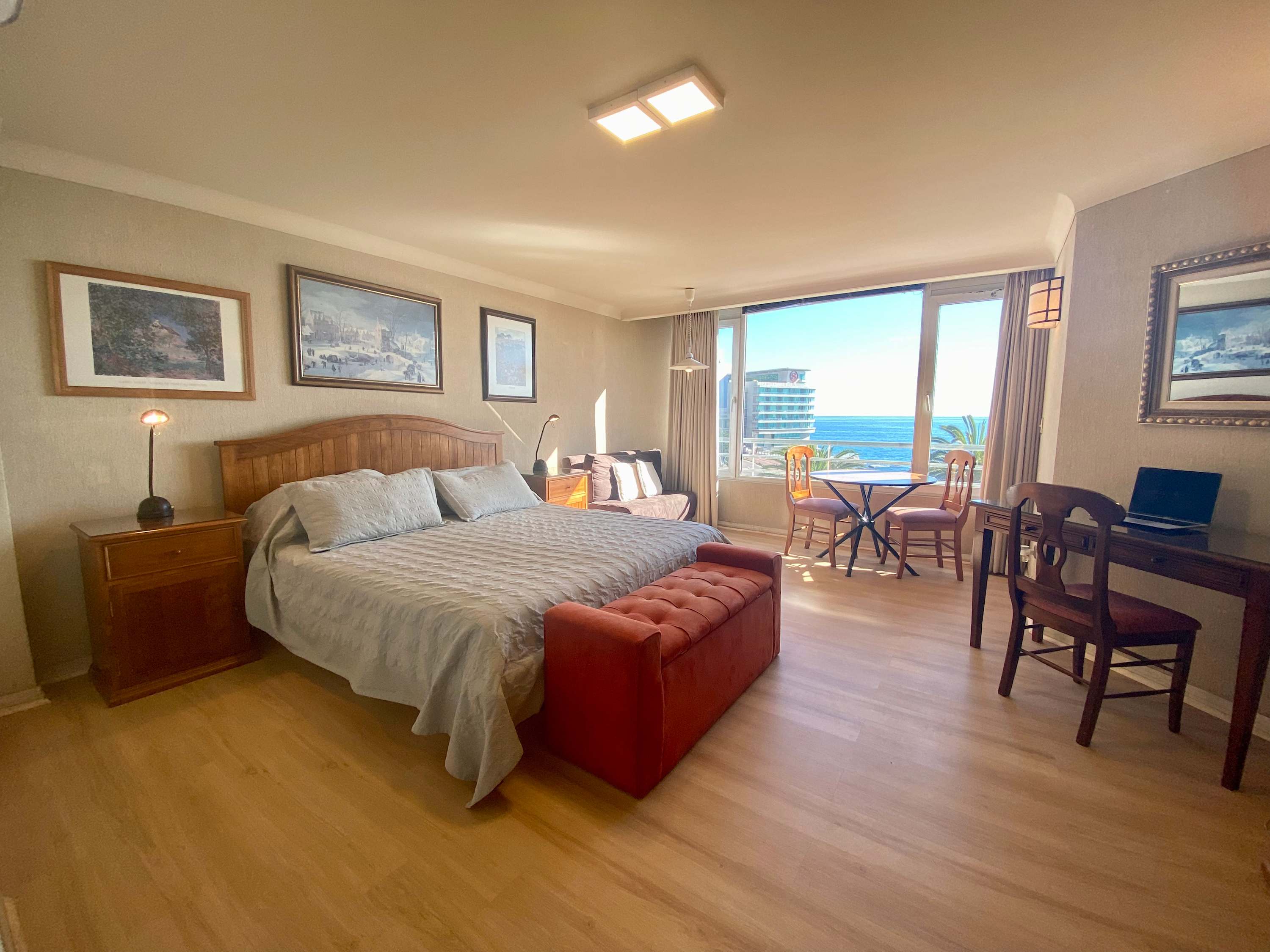 Studio with king bed, desk, dining nook and ocean view
