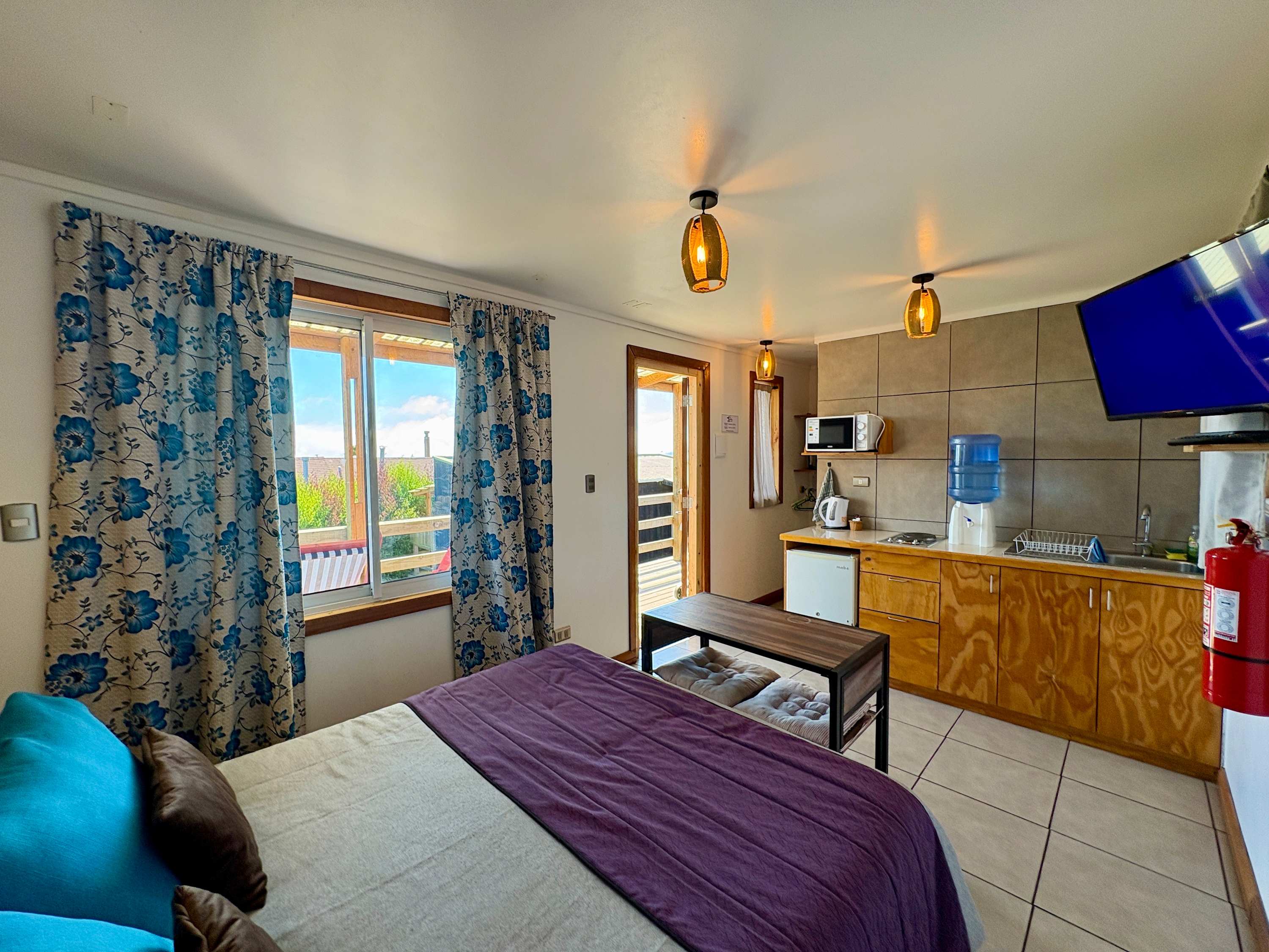 Studio with bed, kitchenette and a window with natural light.